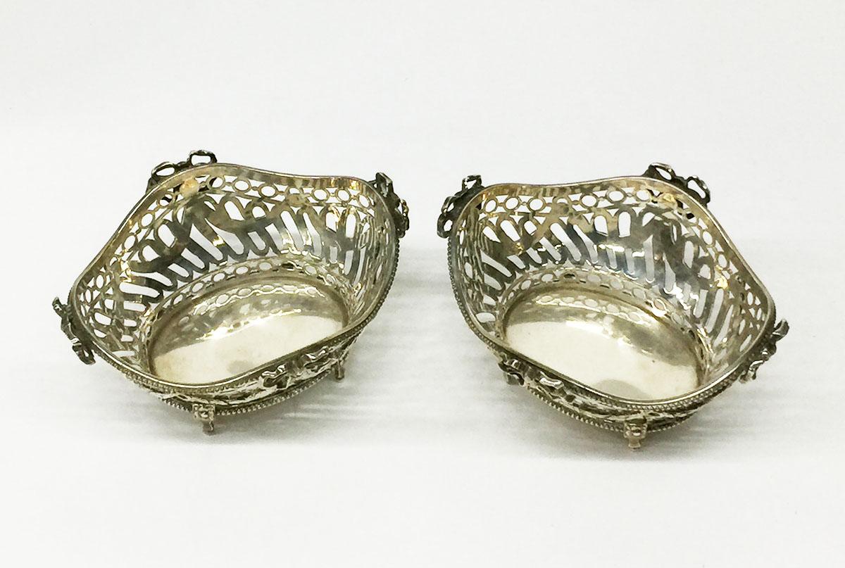 Silver bonbon baskets from Fa. G.C. Reeser and Son, 1902

Silver baskets, The Hague, dated 1902 with openwork silver and garlands and bows. Top and bottom of the baskets with pearl edge. The baskets raised on 4 standing legs, which one of the