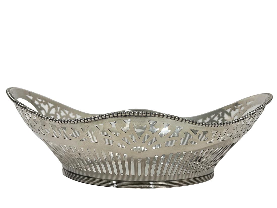 Dutch Silver Bread Basket, Schoonhoven, 1966

An oval round Dutch silver bread basket with openwork decor and pearl rim. The basket has
a scalloped shape with openwork handles
The basket is Dutch silver hallmarked with the silversmith hallmark of J.