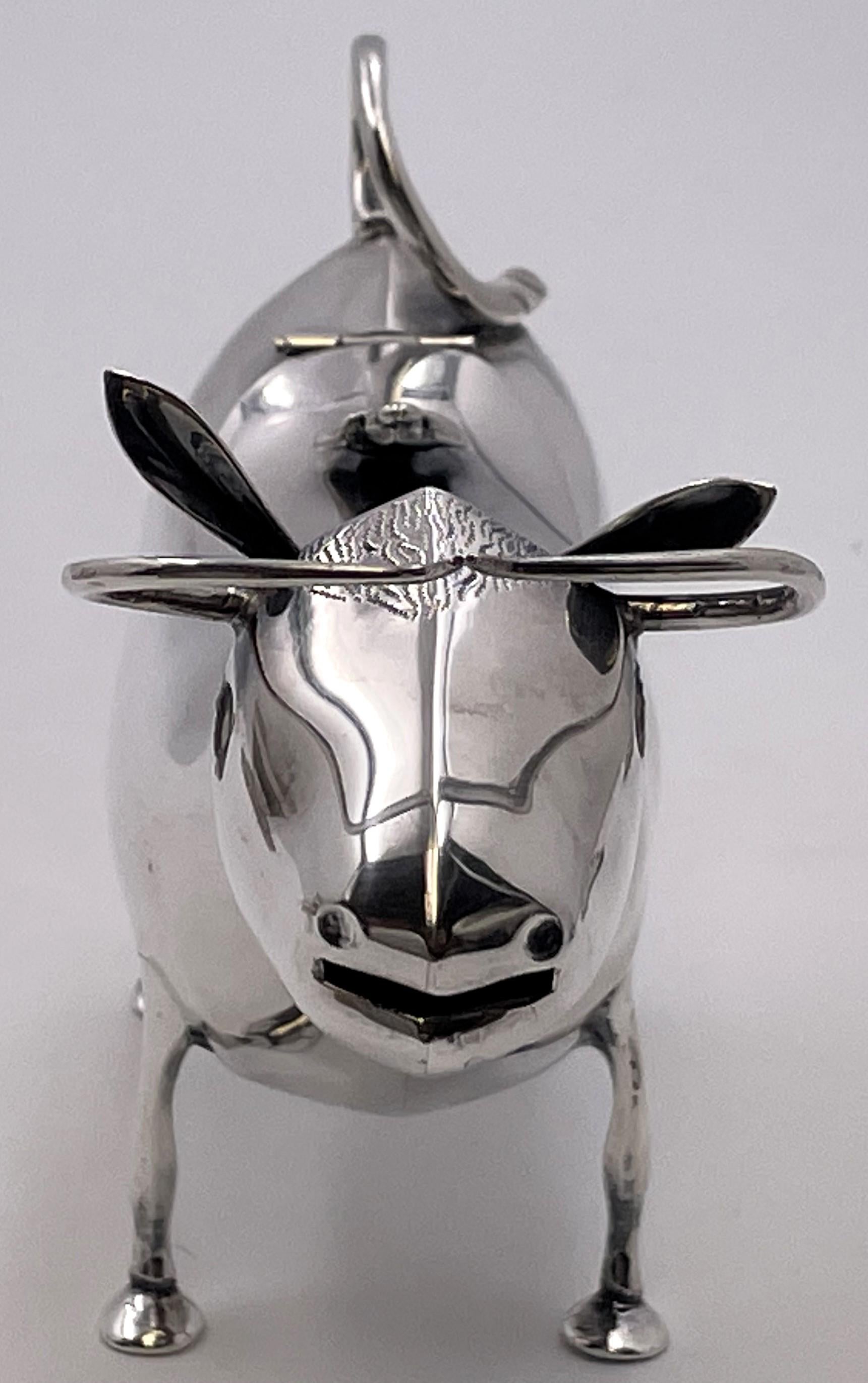 Dutch silver cow creamer from the 20th century, with an applied bee motif adorning the lid. It measures 5 1/3'' in length by 1 3/4'' in depth, weighs 4.7 troy ounces, and bears hallmarks as shown.

Please feel free to ask us any questions, and