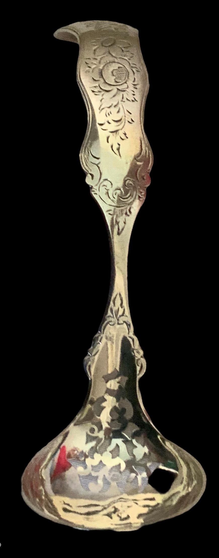 This is a Dutch Silver gravy or sauce small ladle/sifter spoon. It is engraved with a bouquet of flowers and leaves in the handle. It is adorned with some engraved birds in the lateral sides of the handle and some scrolls in the lower part. It is