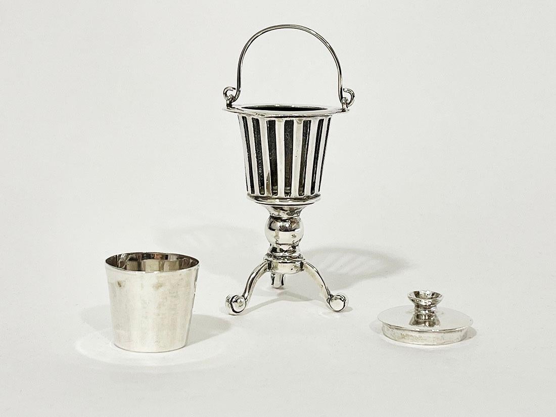 Braciere olandese in miniatura in argento su base a treppiede, XIX secolo

Un braciere olandese in miniatura in argento su una base a treppiede con un secchio con coperchio all'interno. 
Il braciere d'argento è in argento olandese con il marchio
