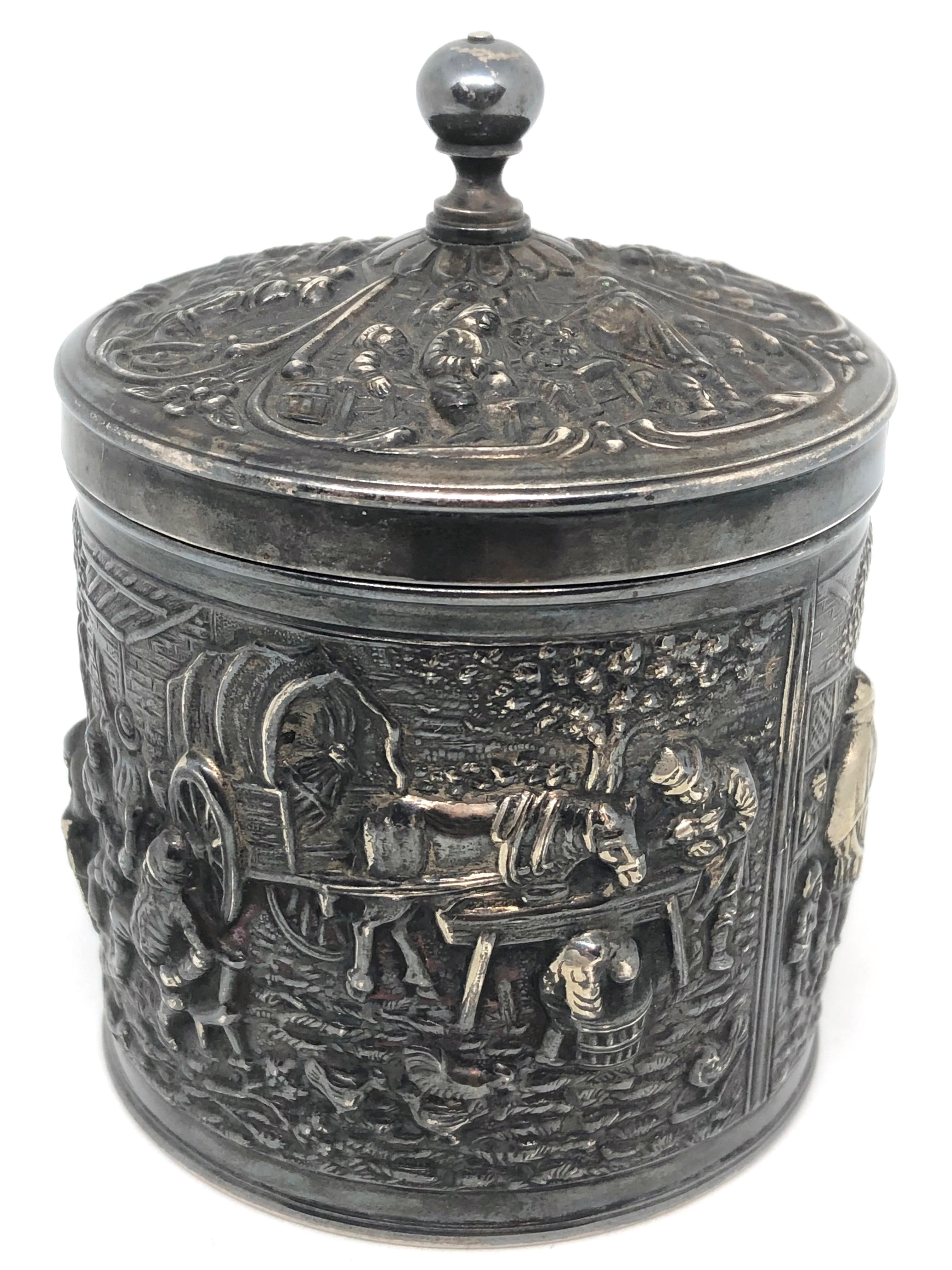 Gorgeous silver plated tea caddy, made by silver factory Herman Hooijkaas for Dutch coffee and tea company Douwe Egberts. The caddy has a hammered decoration of a wagon and horse and a group of people making music. Found on a estate sale in Malmo,