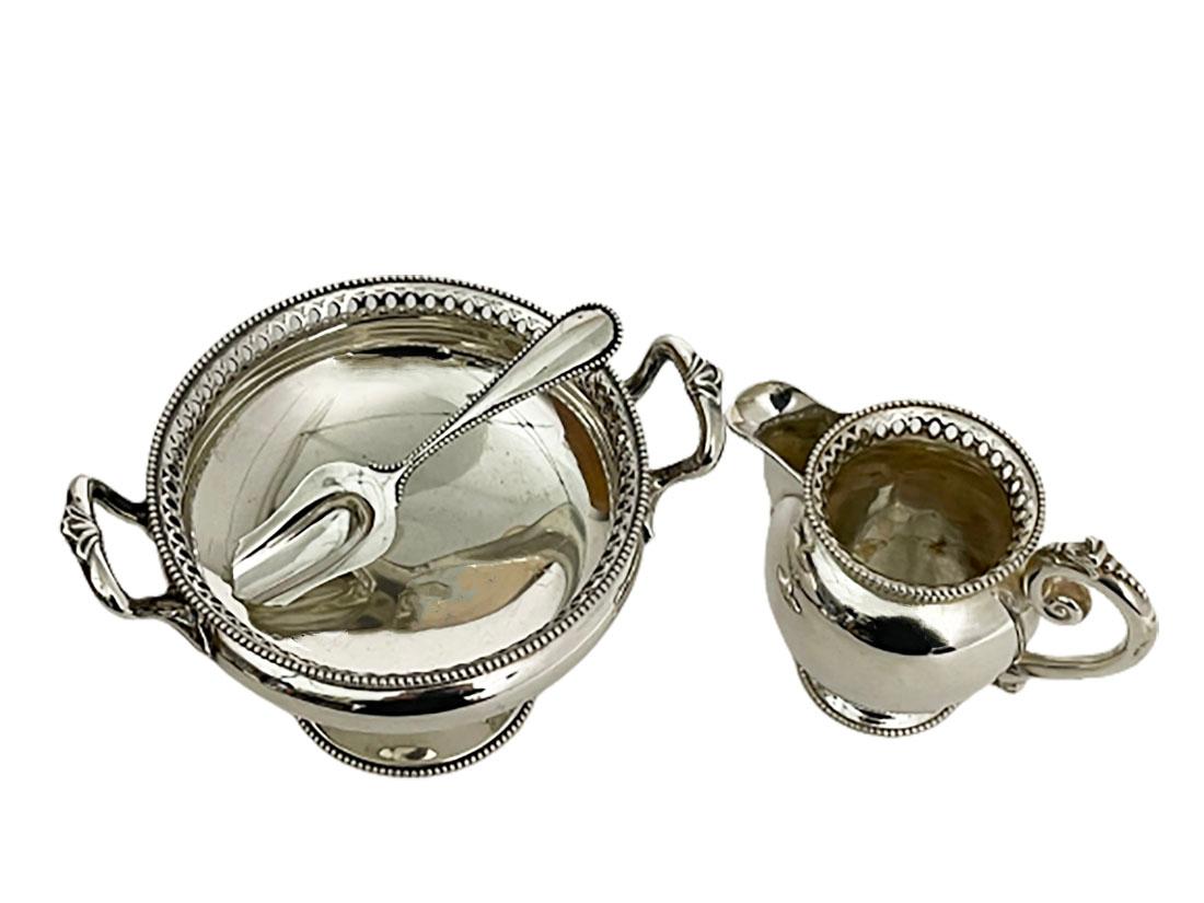 Dutch silver sugar and cream set, Van Kempen & Zn, Voorschoten, 1889

Silver sugar bowl, raised on a round foot and openwork with pearl pattern rims and handles
A milk jar with scrolled leaf pattern ear handle is also in the same pattern, date