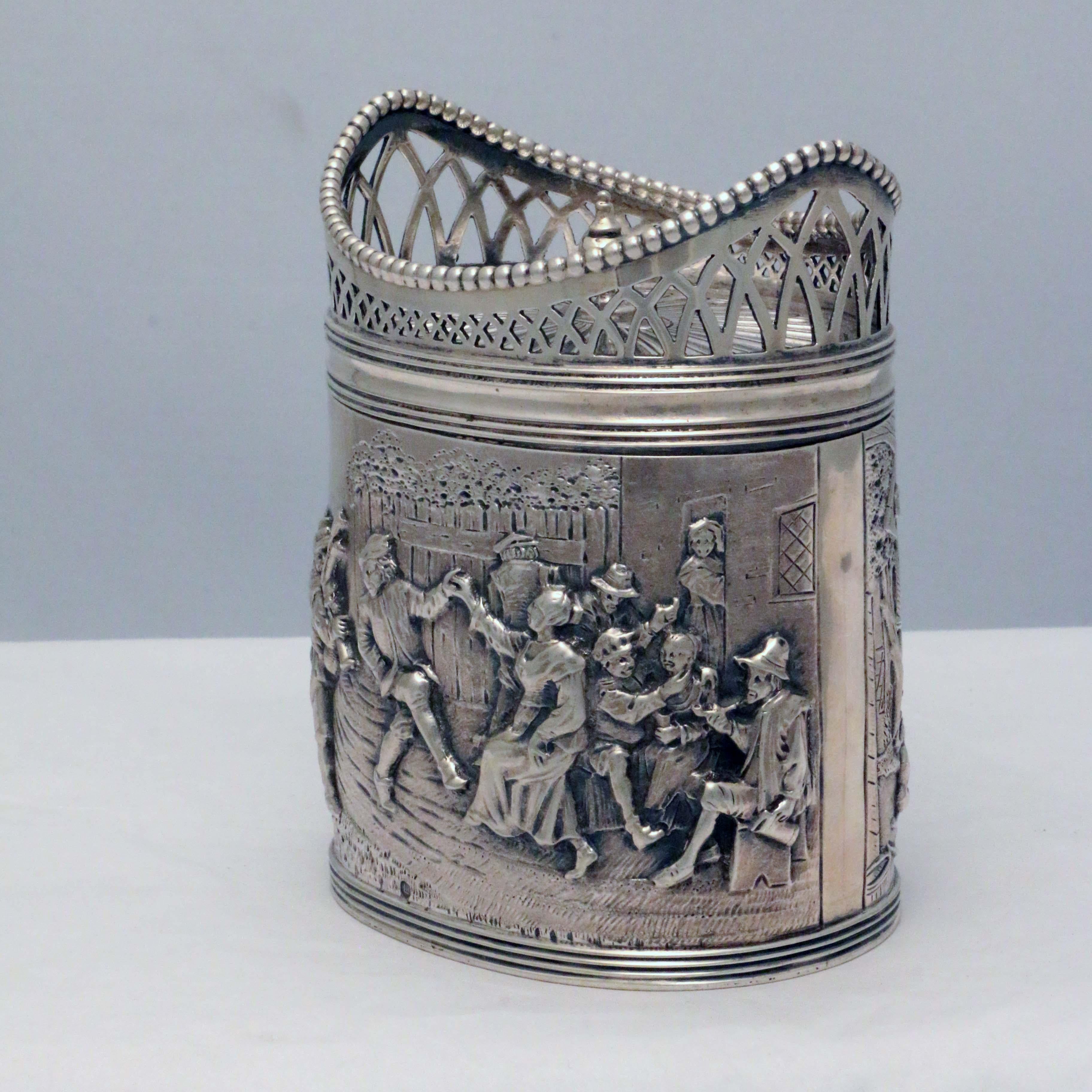 Of oval outline; the body repousse with scenes of merrymaking, after Teniers, the hinged cover with radiating design and pierced gallery. Very well-made, this is a cheerful Dutch box perfect for tisane, China tea, Indian tea or anything else herbal