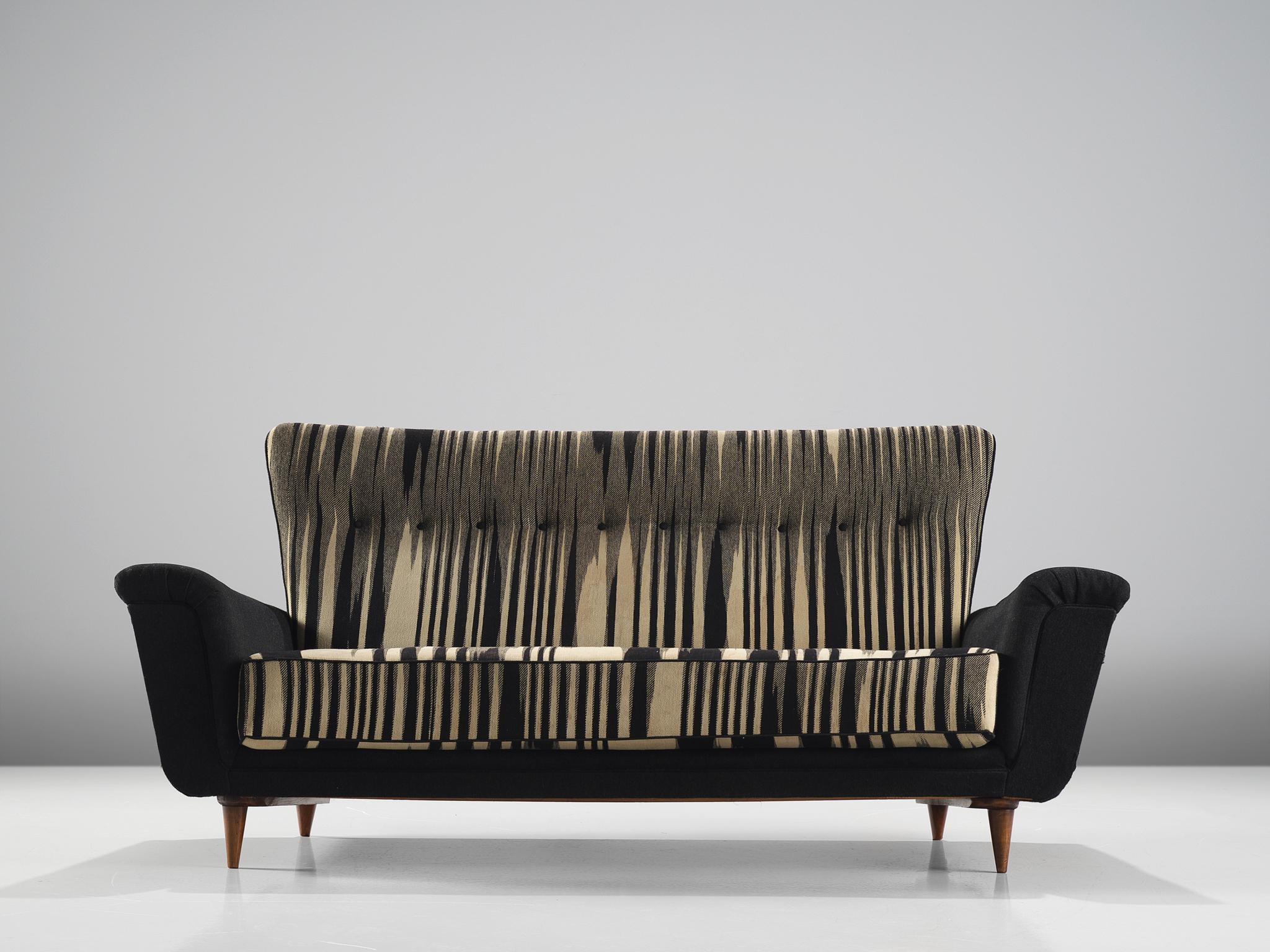 Artifort sofa, black and white fabric, wood, The Netherlands, 1950s.

This sofa is an iconic example of Dutch design from the 1950s. The sofa is on the one hand simplistic, with elegant, subtle lines. On the other hand the settee has a certain