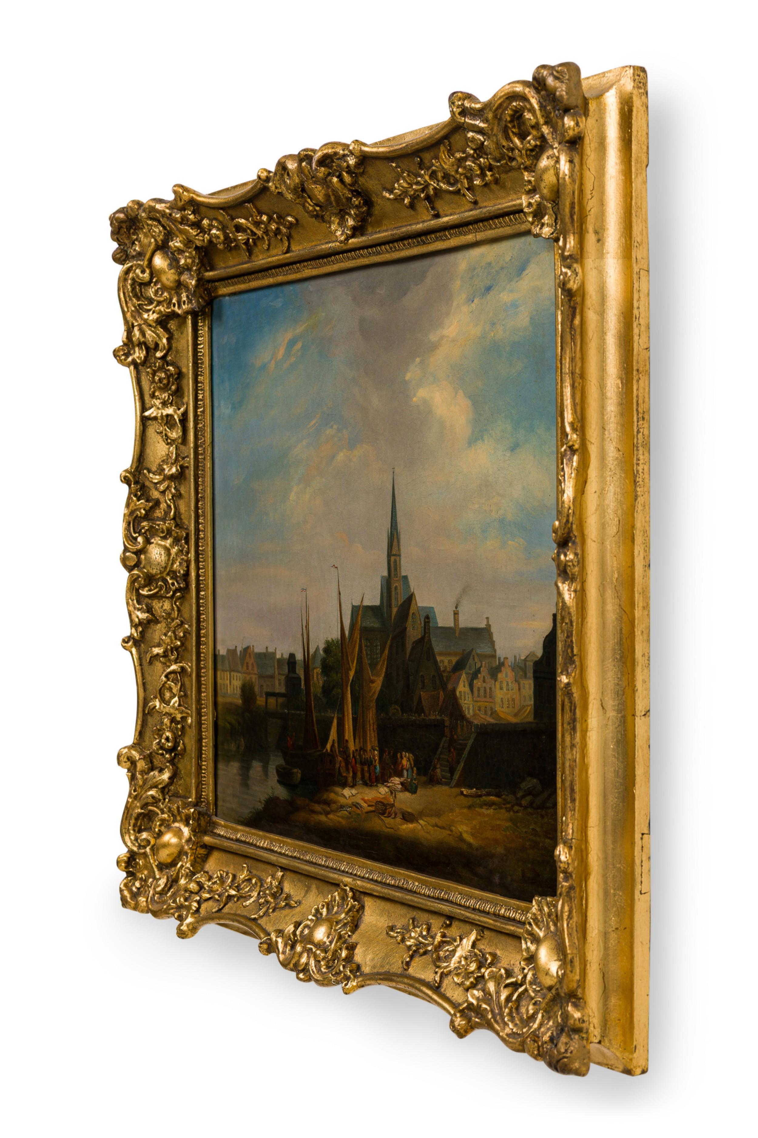 Peinture à l'huile de style hollandais (19e siècle) représentant une scène avec des bateaux de pêche amarrés et des personnages avec une grande église à l'arrière-plan dans un cadre sculpté à l'or fin (non signée).