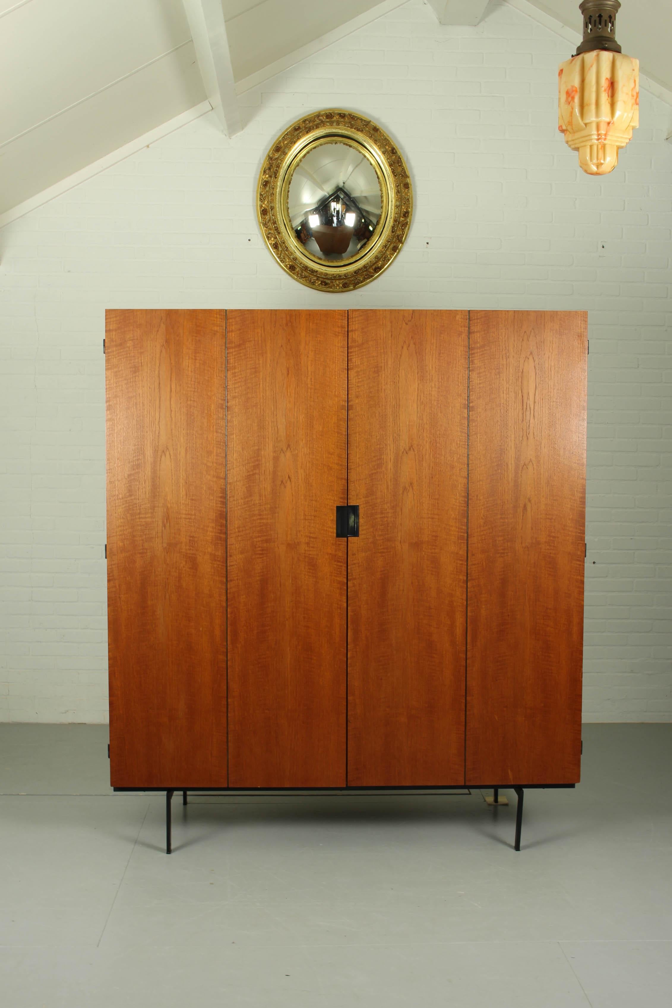 Wardrobe KU14 Cees Braakman Pastoe Japanese series 60s. It has two doors in teak with an additional folding mechanism, revealing four storage spaces. Iconic square black metal handles make it a piece o the very recognizable Japanese series.
 