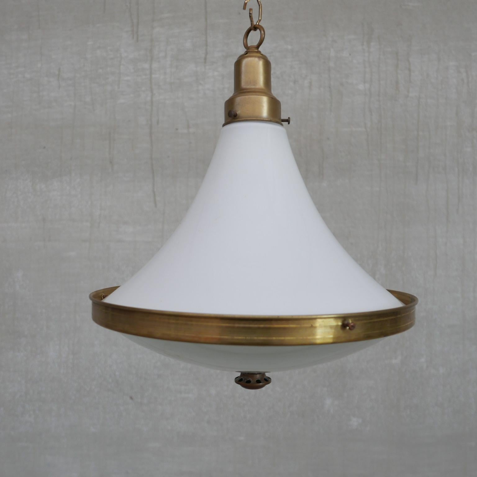 A two tone glass pendant light. 

Holland, c1940s. 

Opaline top glass, etched glass base, brass gallery and rim, terminating in a brass finial. 

Since re-wired and PAT tested. 

Location: Belgium Gallery. 

Dimensions:32 Diameter x 40