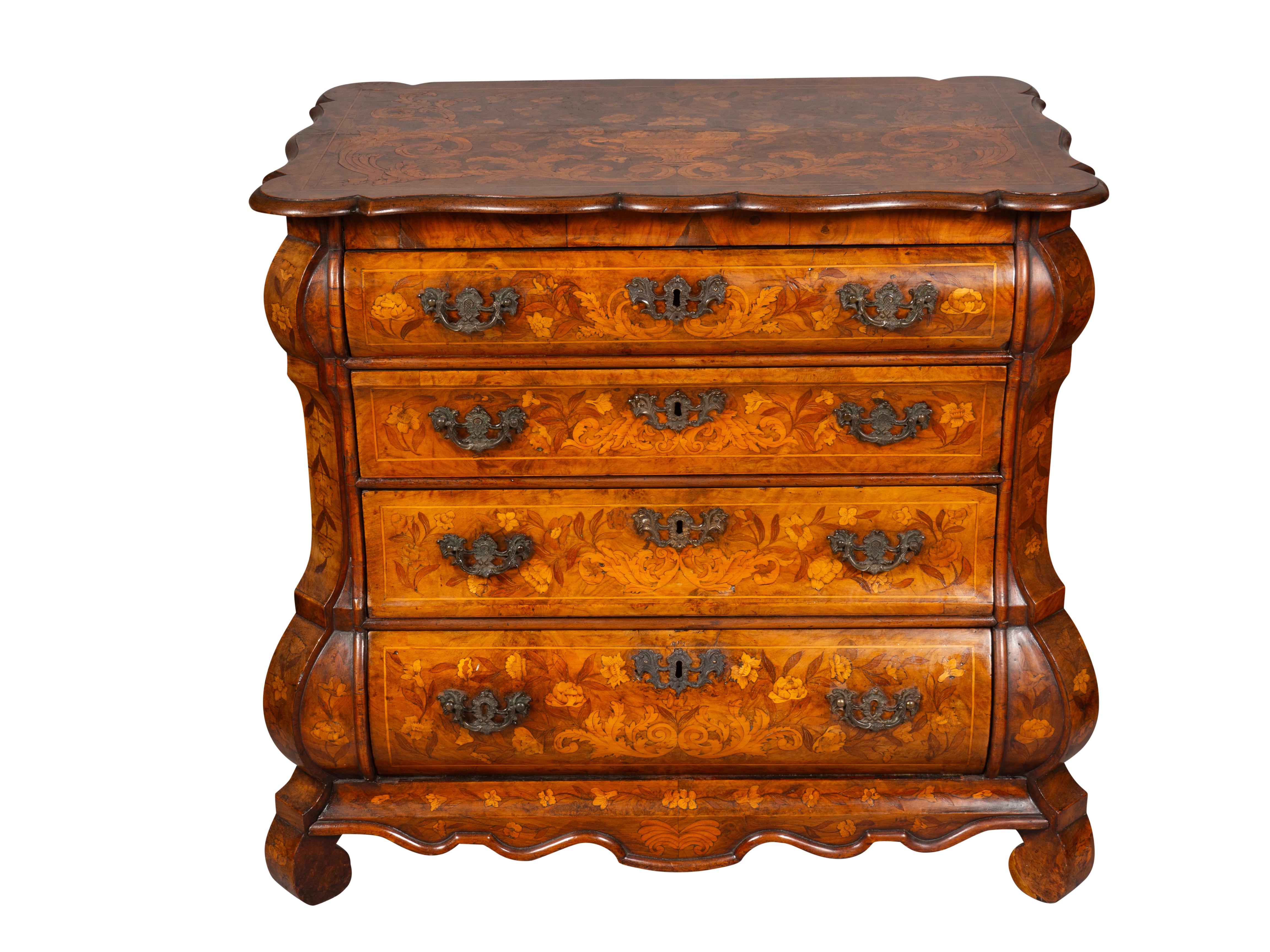 With a shaped rectangular top with elaborate floral inlay over a conforming case with four drawers ending on scroll feet. Very nice floral marquetry overall with subtle gently faded walnut with rich patina. Not a piece I typically buy but this is