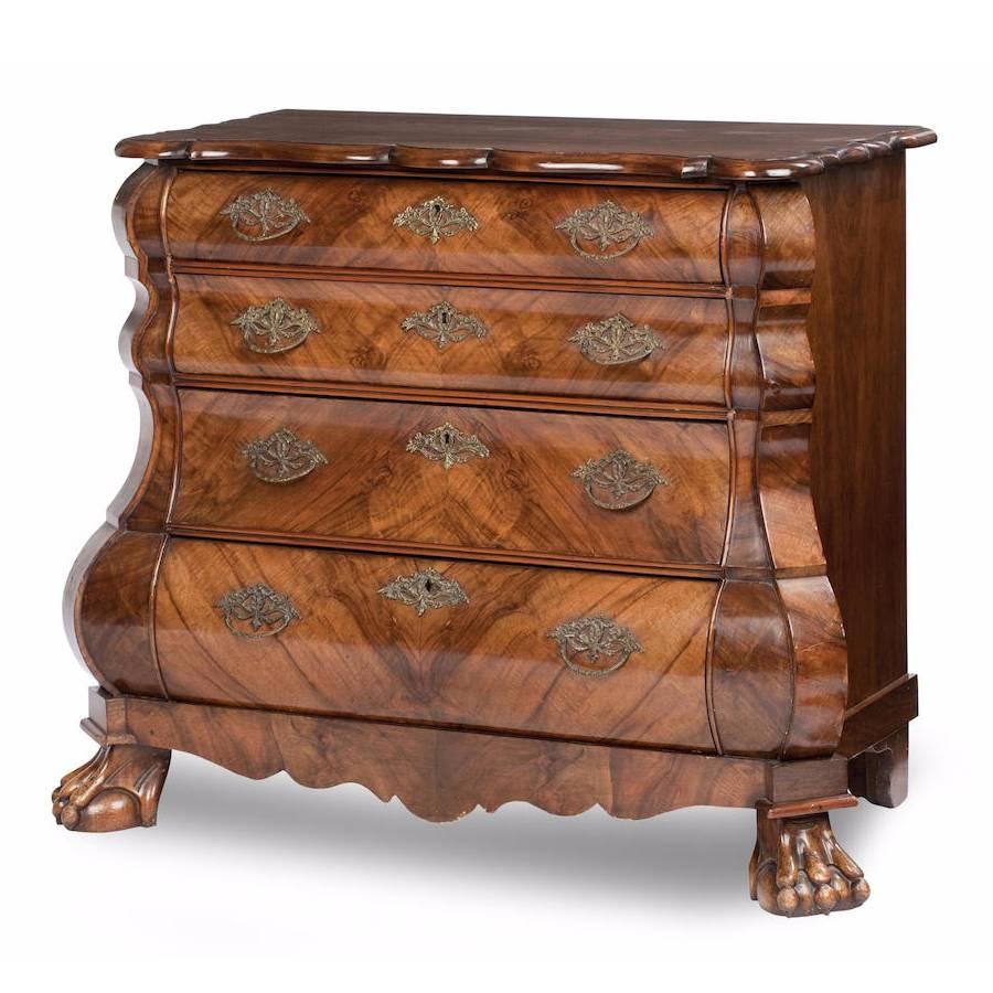 Dutch walnut bombé chest, circa 1840. The rectangular top with serpentine moulded edge above four long graduated drawers within cascading front corners and raised on claw and ball feet.