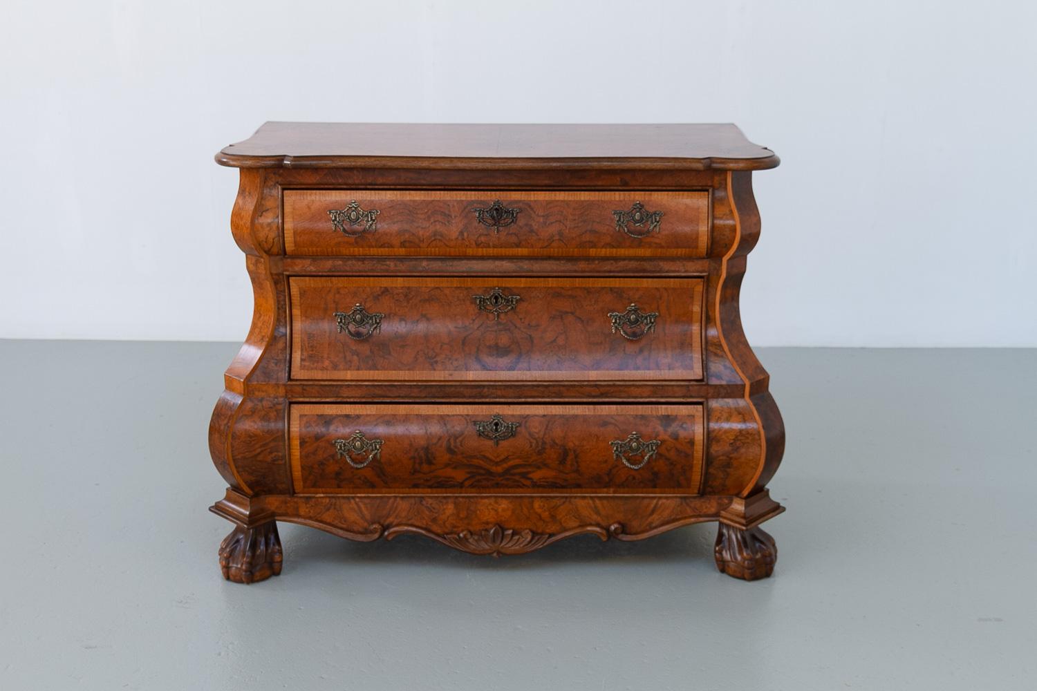 Dutch Walnut Bombe Commode, 1910s.

Wonderful antique Dutch burr walnut bombe dresser. Front with double serpentine shape, bronze fittings and three wide drawers. Stands on original ball and claw front feet.
Complete with original locks and key.

A