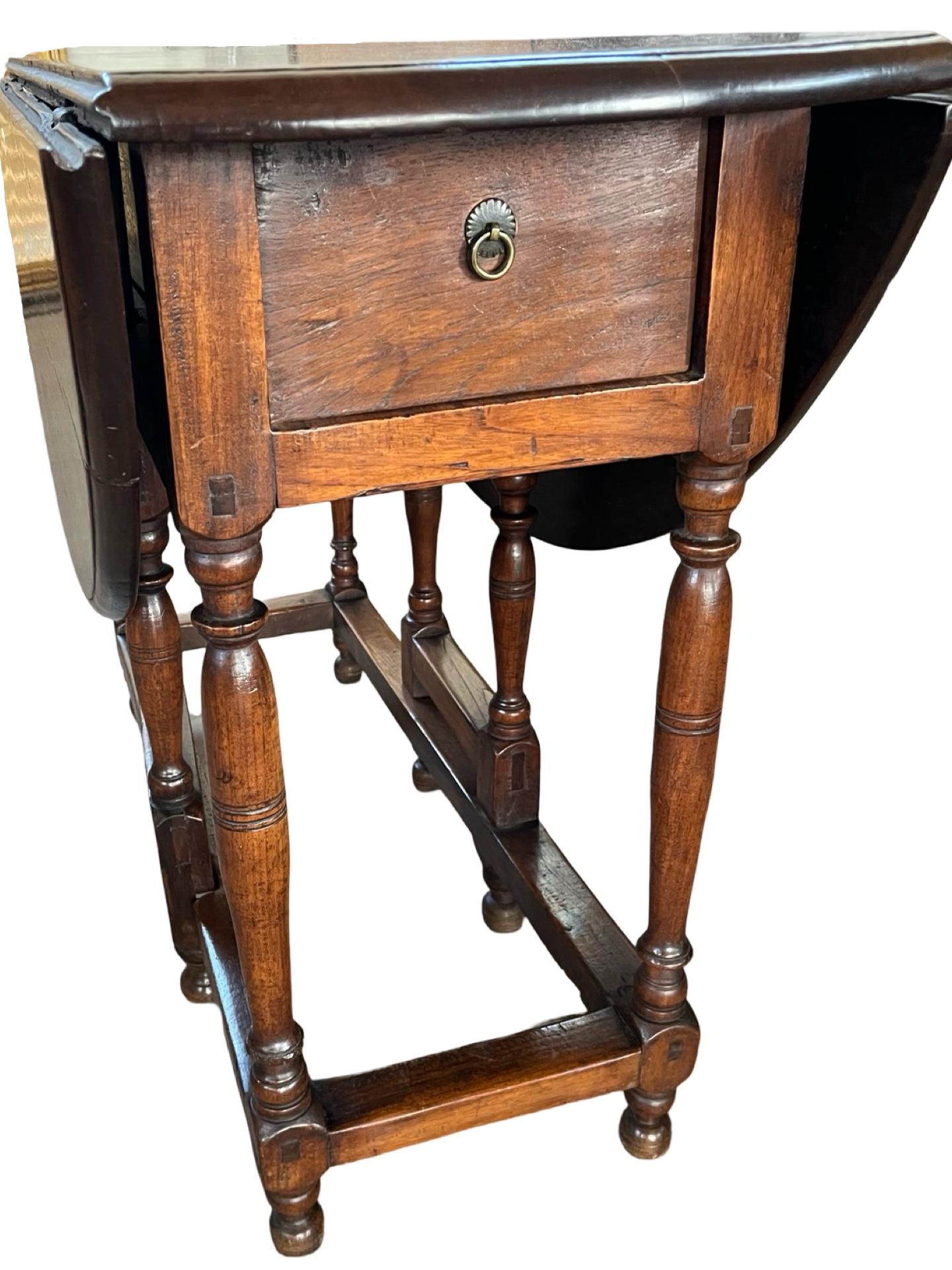 Table à abattant fabriquée à la main aux Pays-Bas au milieu des années 1700, en noyer et avec des chevilles. Le pied de la porte s'ouvre sur une forme presque ronde de 111 cm x 113 cm (43,7 x 44,5 pouces). Les deux vantaux sont constitués d'une