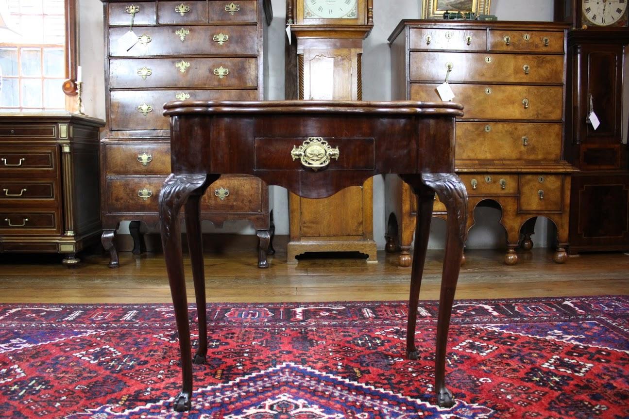 Mid-18th century Dutch shaped top games table in walnut standing on carved cabriole legs with claw and ball feet. Games table features double flip top. The flip top first opens to reveal dished playing interior and the second flip of the top reveals