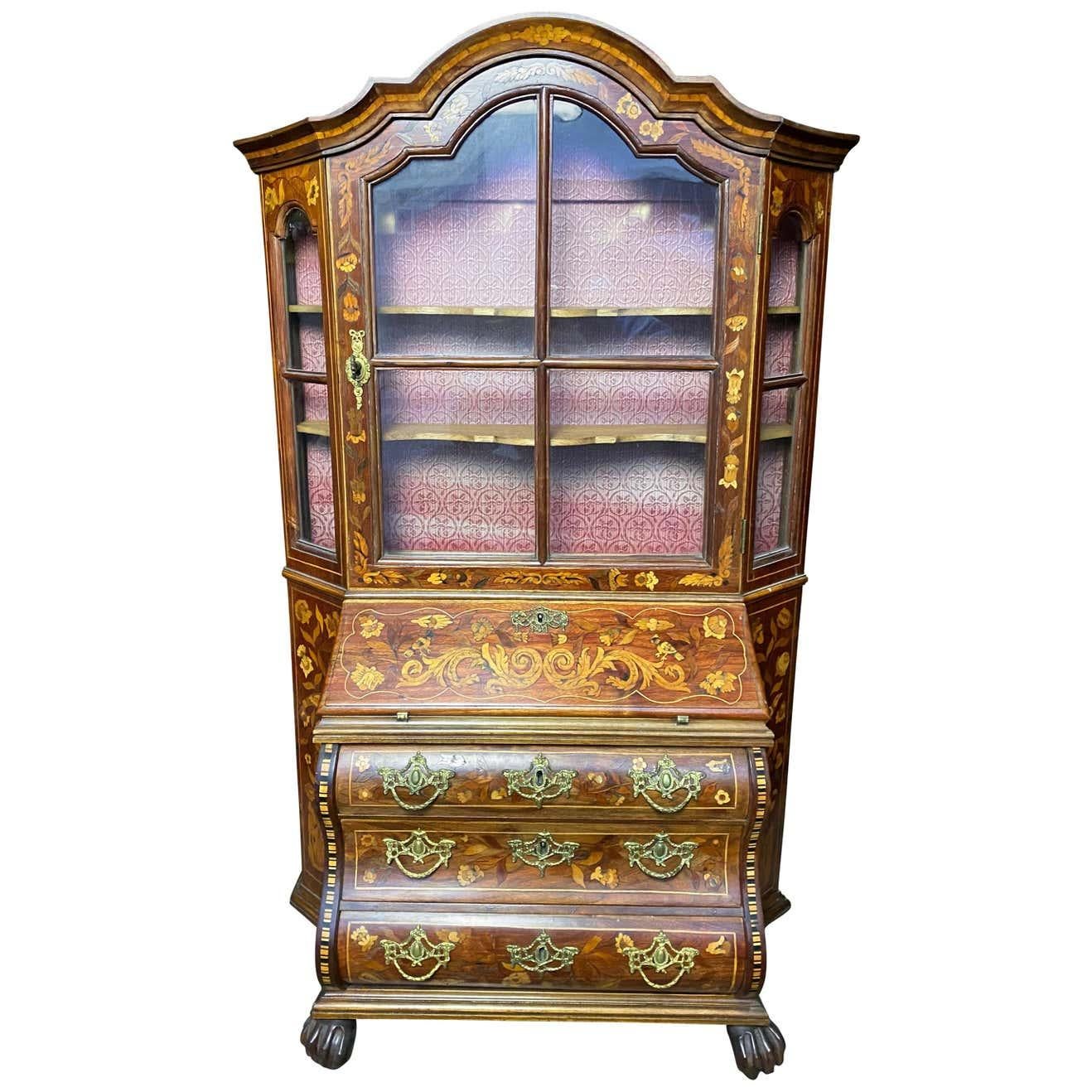 An 19th century Dutch walnut secretaire bookcase with undeniably striking colours. Several shelves open up to various platforms to provide a beautiful interior with a lock and key mechanism on the main door. A beautiful floral design extends over