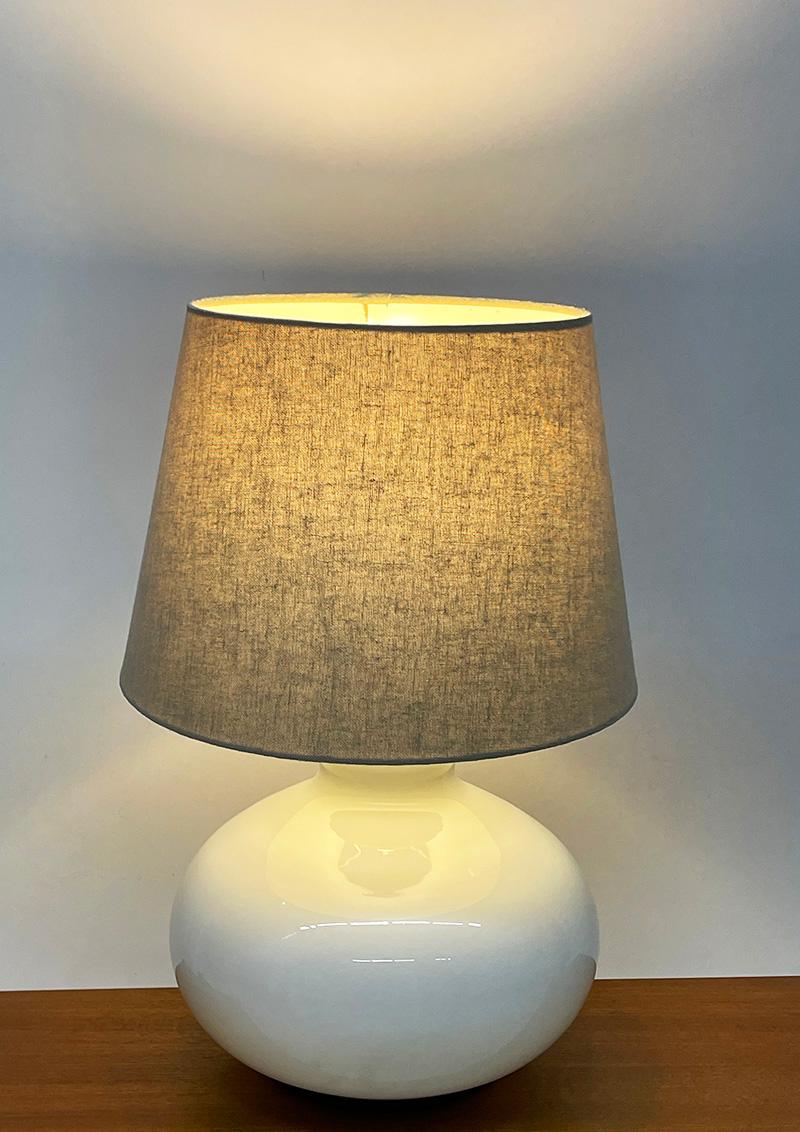 Dutch white glass table lamp by Dijkstra, 1970s

Hand blown white glass globe base, by Dijkstra Lampen B.V., Cruquius, The Netherlands. Two Bakelite E27 sockets with a built-in switch on top. This table lamp has a built-in switch to use the two