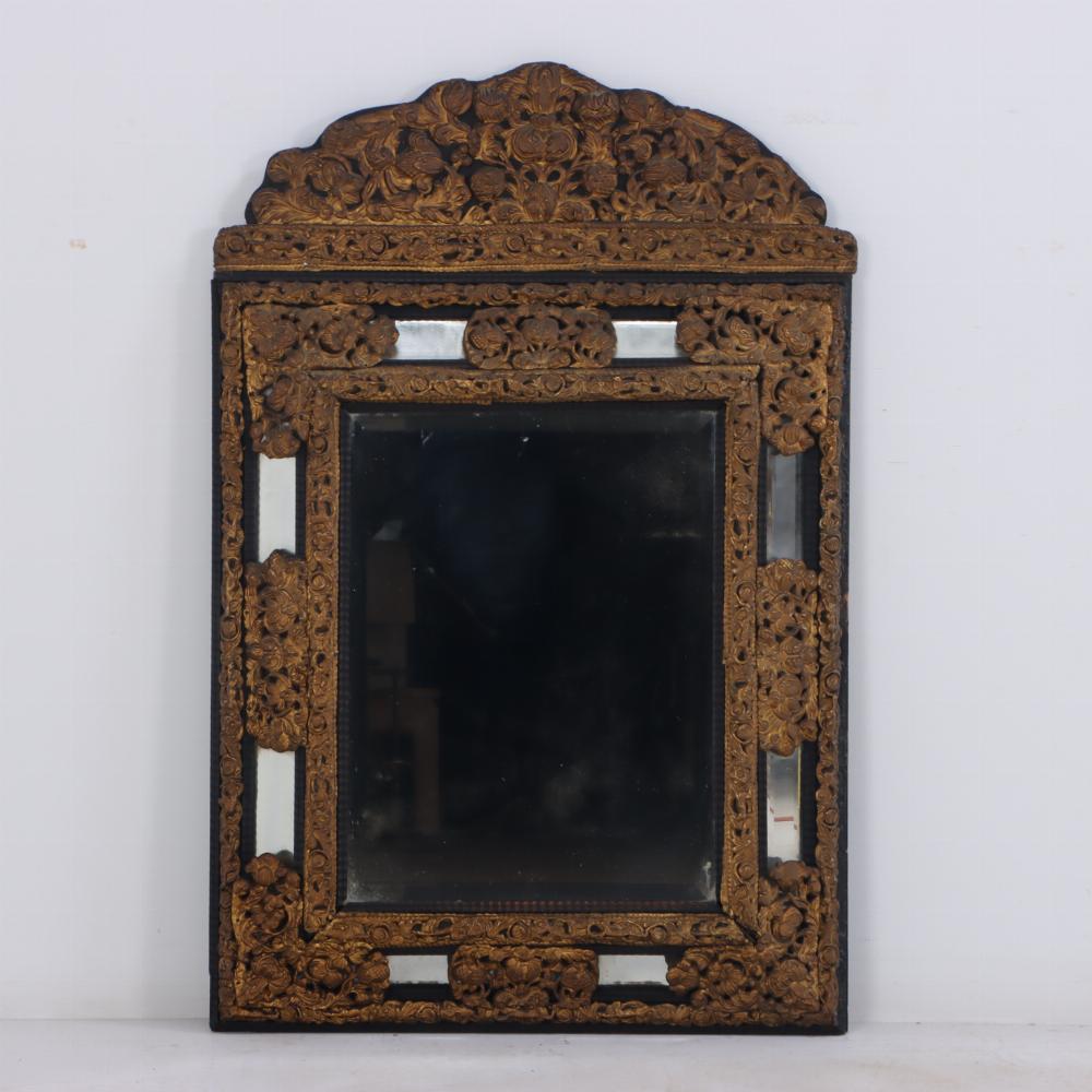 Specchio olandese in legno e ottone sbalzato, XIX secolo, caratterizzato da uno stemma traforato e sagomato molto decorato su una cornice rettangolare impreziosita da disegni floreali e fogliati in ottone.