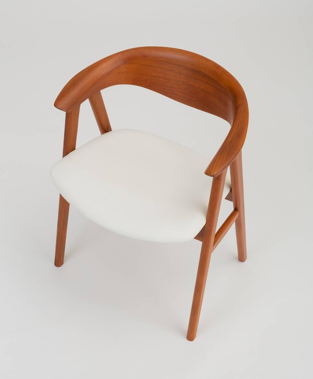 Designed in 1952 as the Model 52 armchair for Høng Stolefabrik, this example was imported to the US by Swedish-American company DUX. The chair has a generous, curved backrest with a wide lip and a broad seat cushion in white leather, supported