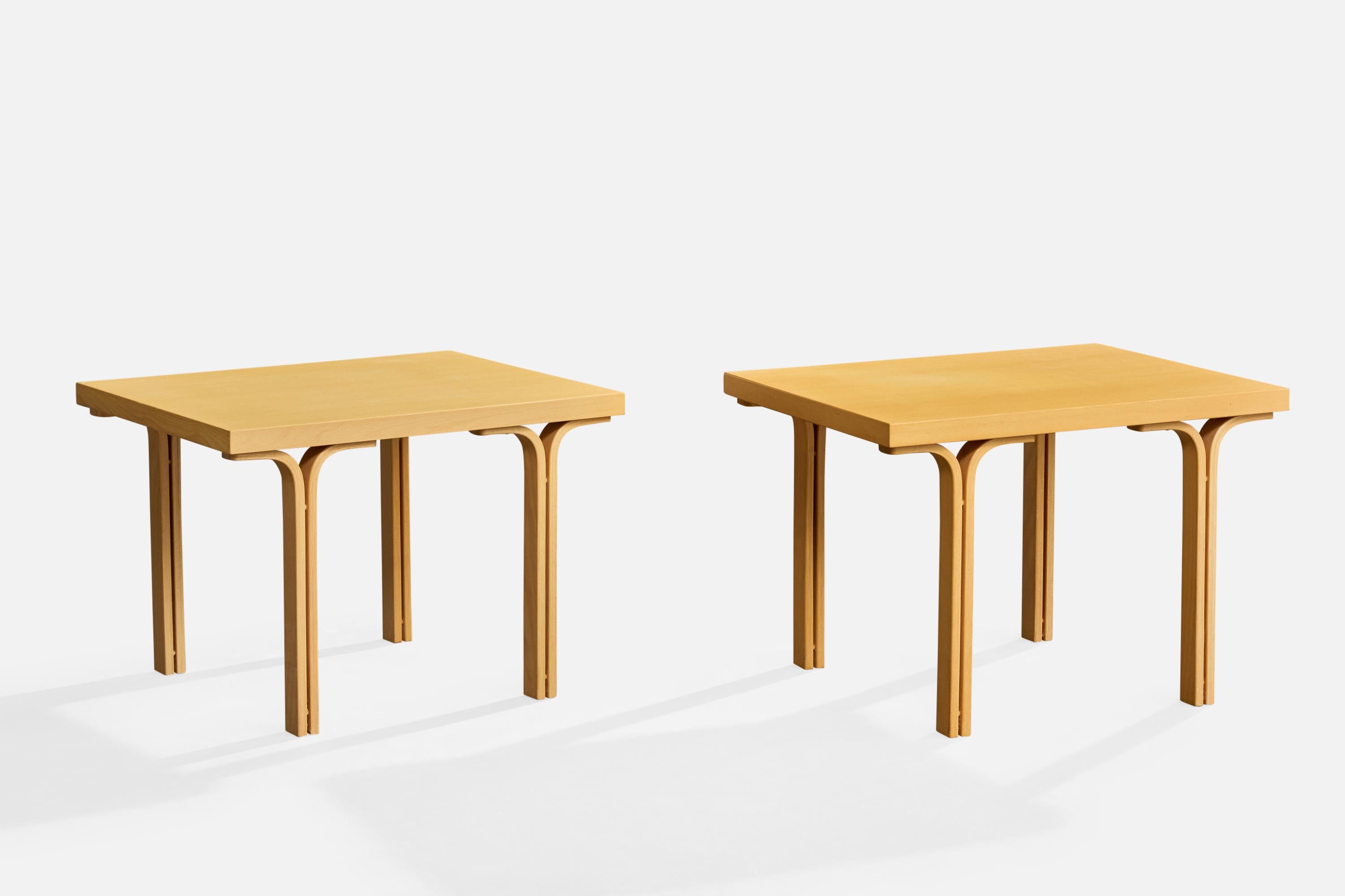 A pair of beech side tables produced by Dux, Sweden, c. 1990s.

One is lighter in color than the other and has one damaged corner.

Both tabletop surfaces have natural cracking from normal use (darker one has more).

Overall Dimensions (inches):