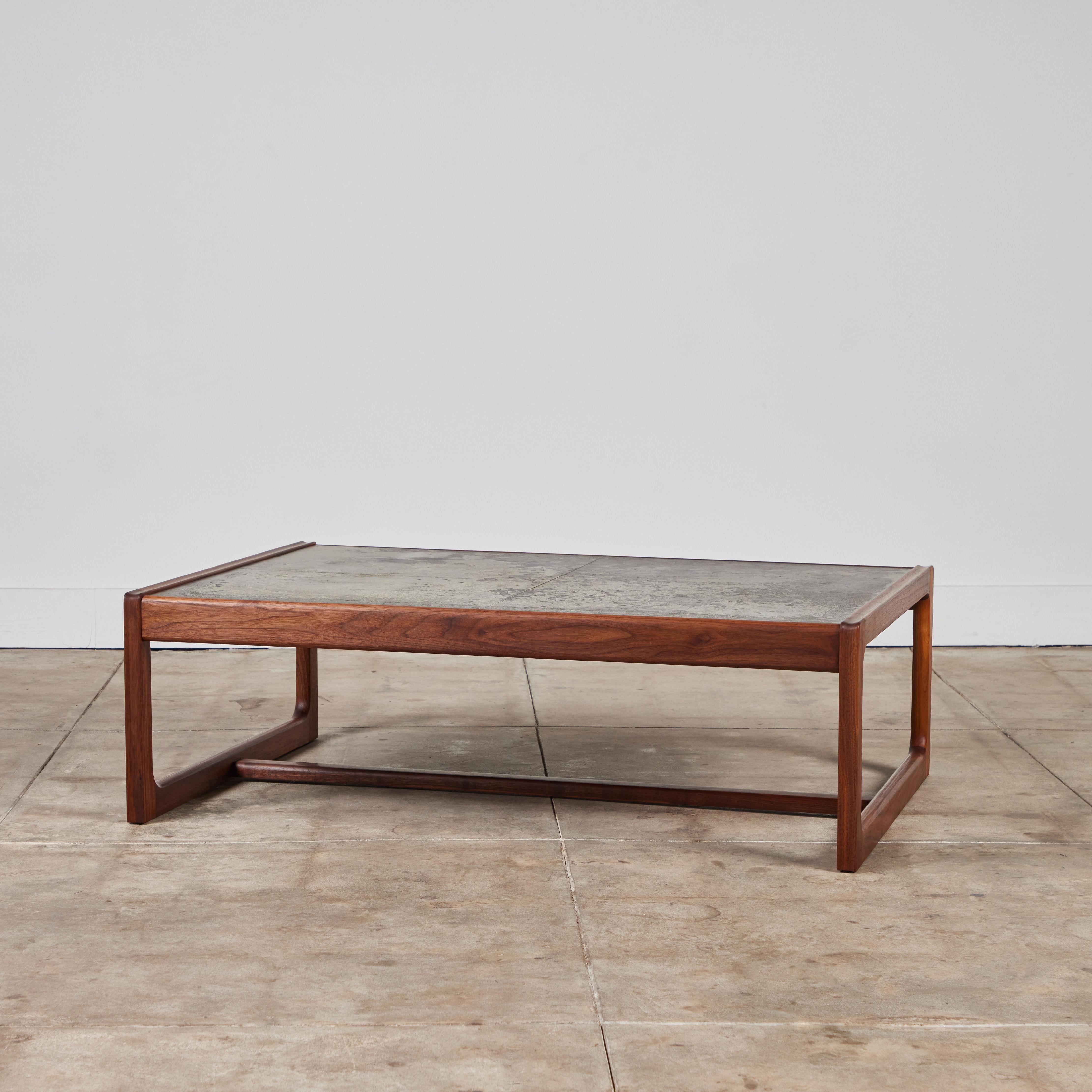 Coffee table for DUX, Sweden, c.1960s. The rectangular table features a teak frame with rounded edges and open sides with stretcher that runs the length of the table along the bottom. The surface of the table showcases a beautifully bronze patinated