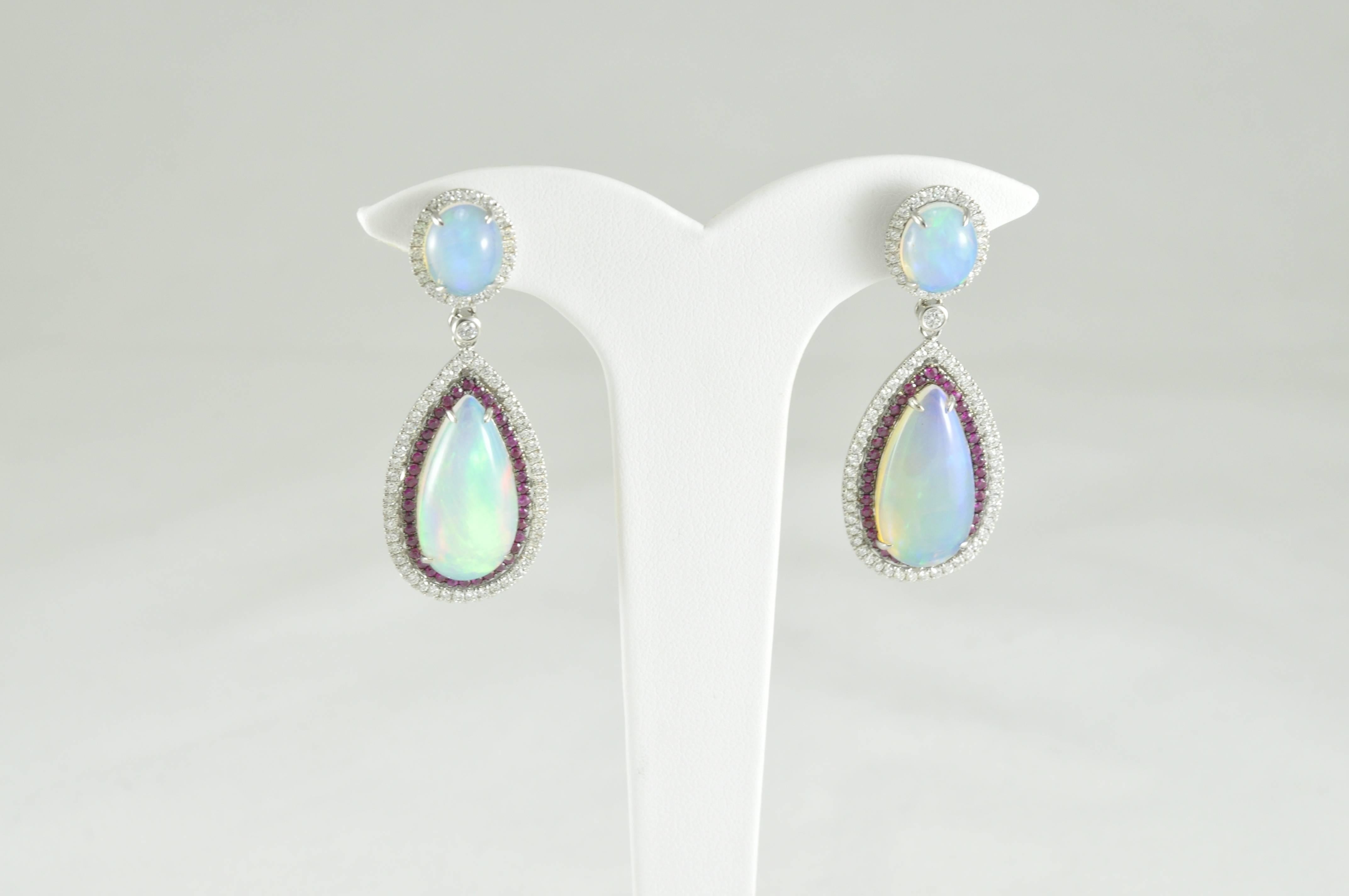 14k White Gold with 13.28CT Opals with Ruby and Diamond Halo.  These earrings are made by Award Winning Designer DVANI.
