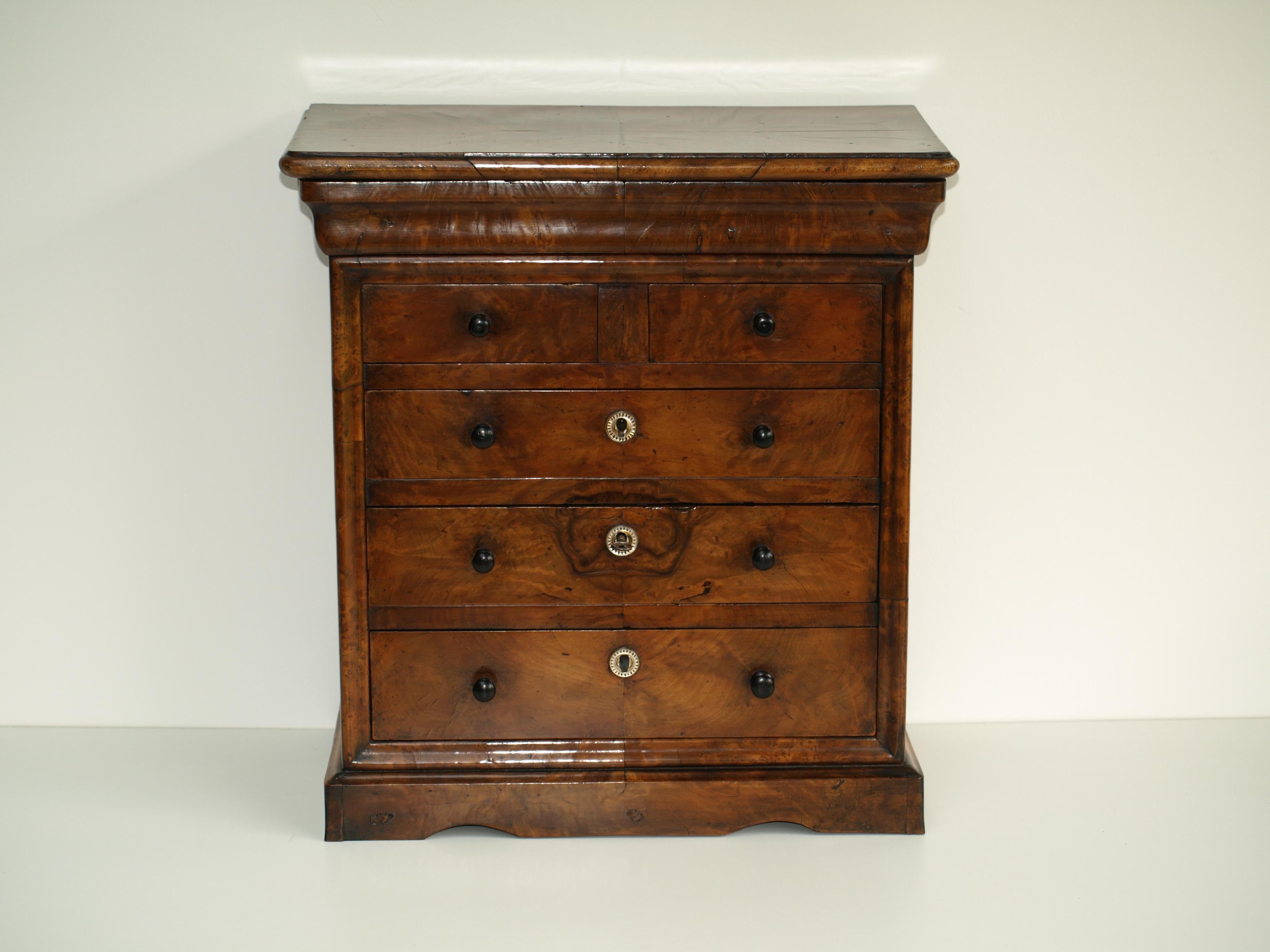Small 19th century French five-drawer chest. The top quarter-veneered in well figured Yew wood and housing a moulded frieze drawer below. The drawers below with matched figured veneers. fitted with ebony turned knobs and mother-of-pearl escutcheons.