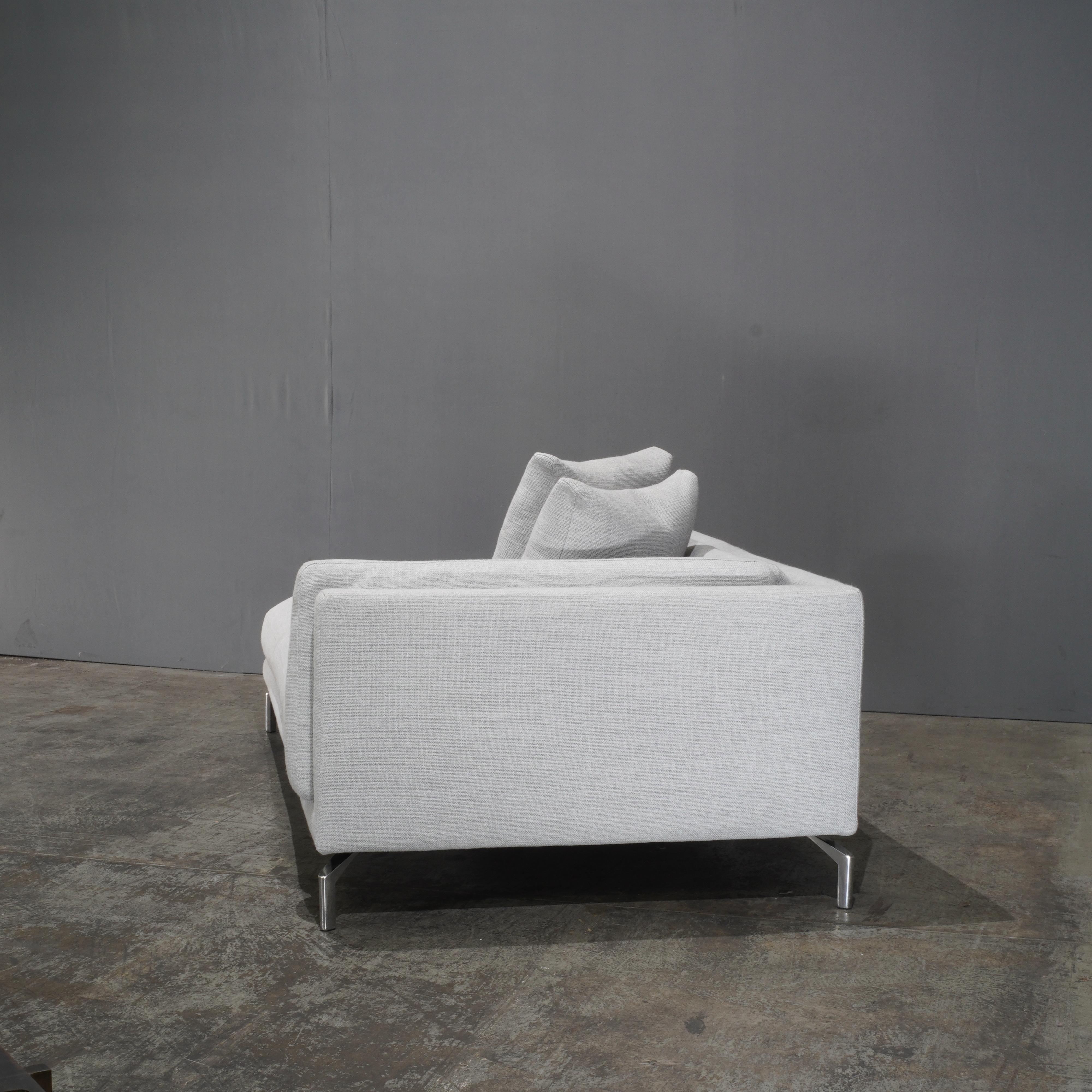 The DWR Grey Como Sofa and Chaise by Giorgio Soressi epitomise understated elegance with their clean lines and sophisticated design. Upholstered in a luxurious grey fabric, the set offers a harmonious blend of comfort and style. The deep seat