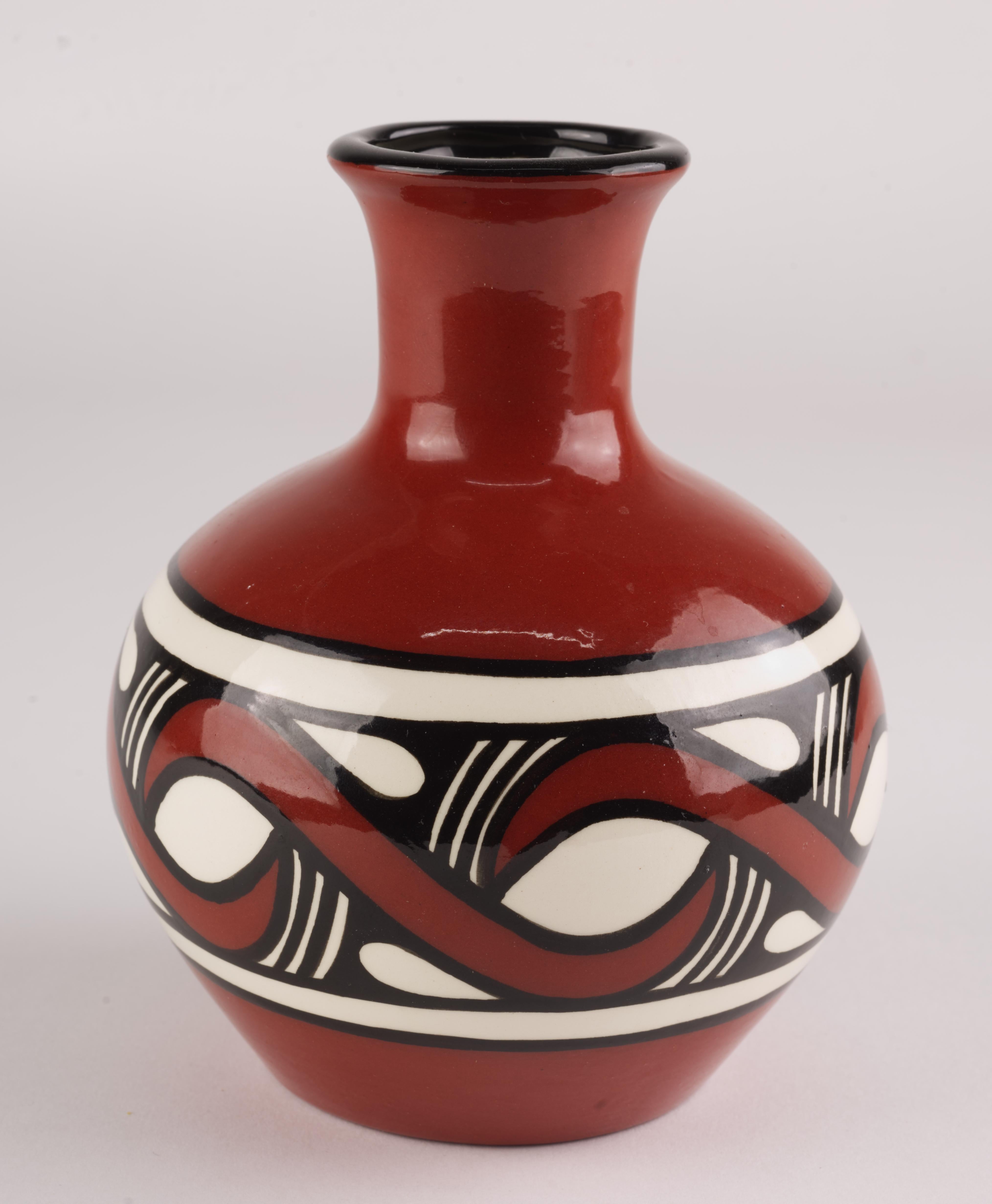  Dyce Ukrainian ceramic handmade bud vase is decorated with Trypillian design in black and white on red clay background. 

The term 