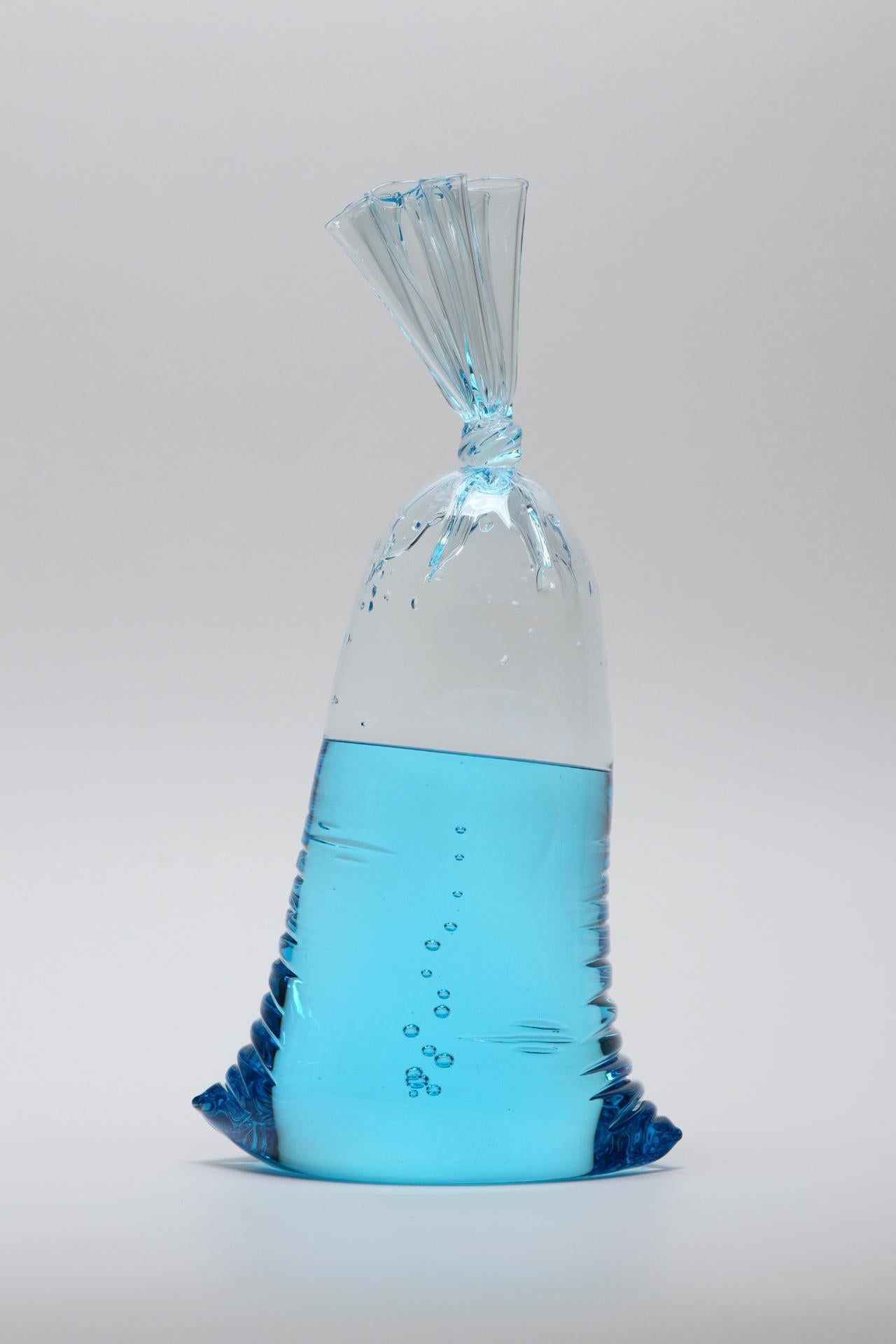 Limited Edition Blue Glass Water Bag Series - Hyperreal blue water bag glass sculpture, solid and hollow glass by Dylan Martinez. 

Dylan Martinez
 hyperreal sculptures are hot sculpted glass, hand molded entirely by the artist. The piece is signed