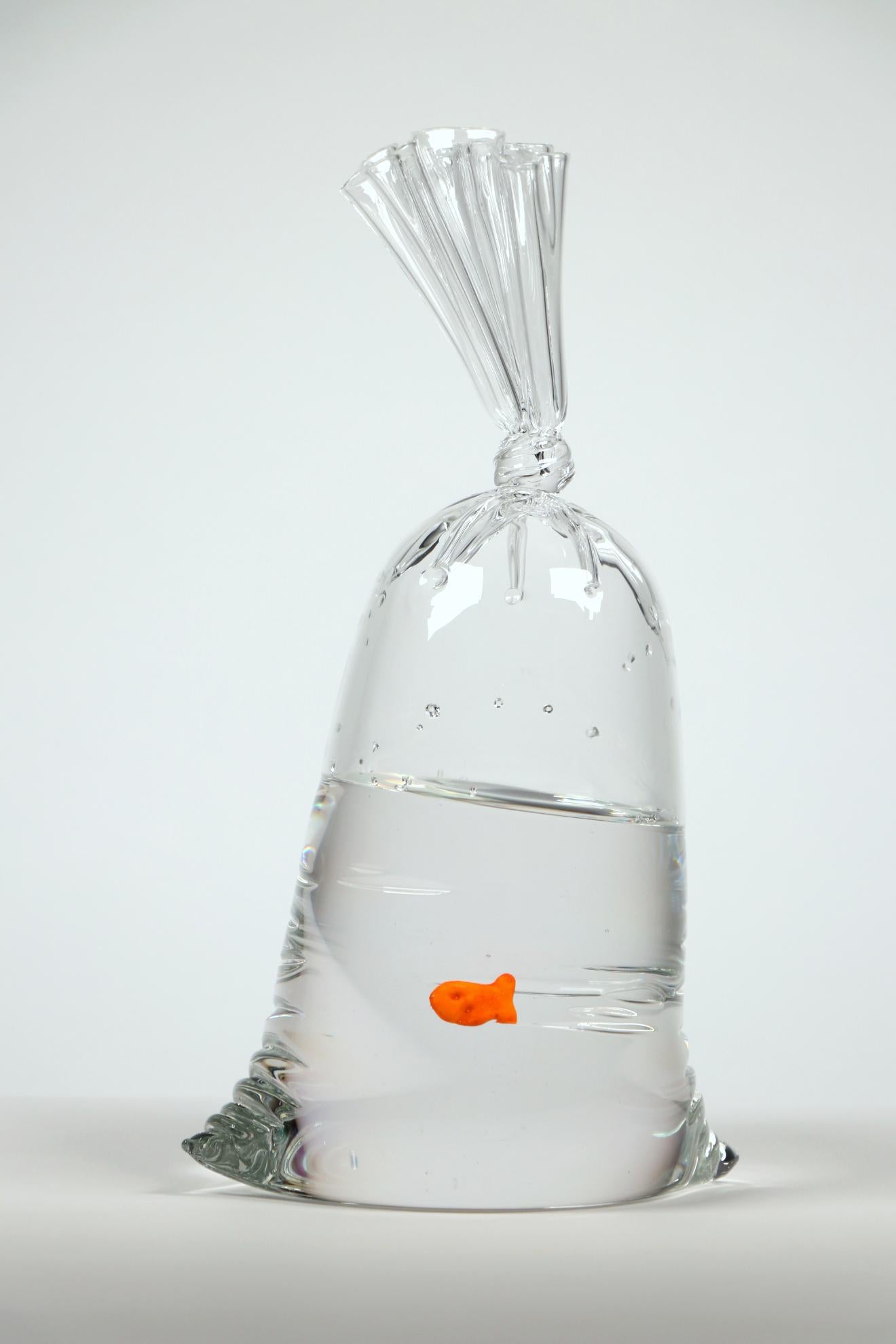 A hyper-realistic glass sculptor, Dylan's playful creations deceive the eye with their lifelike appearance. Whether mimicking water balloons or plastic bags filled with water housing a goldfish cracker, each piece is meticulously designed and