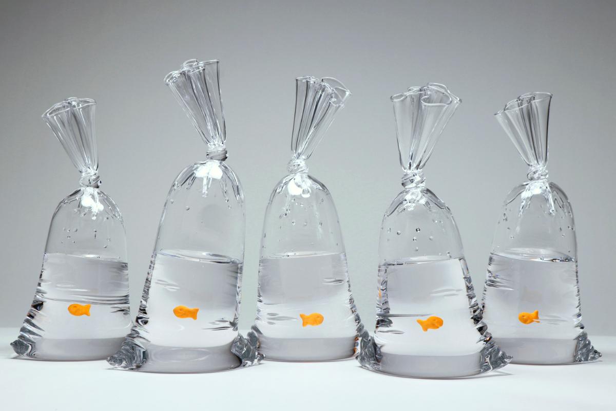 Die limitierte Auflage dieser hyperrealen Goldfisch-Cracker-Wassertüten aus Glas ist eine verspielte Anspielung auf die Karnevals-Goldfische in Plastiktüten. 

Jedes Stück, das mit geschmolzenem Glas bei über 2000° F hergestellt wird, ist