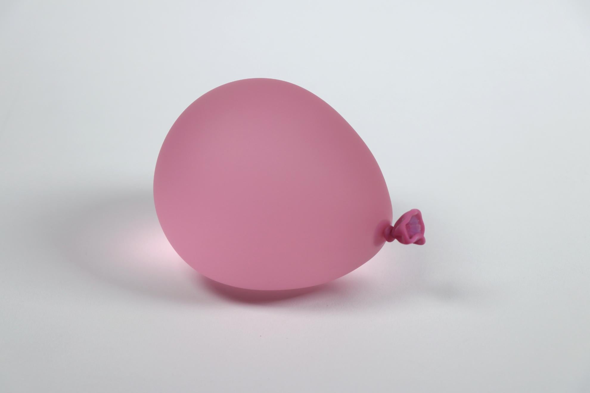 Pink hyperreal glass water balloon sculpture by Dylan Martinez. 

These hyperrealistic water balloons are made of solid sculpted glass sandblasted and acid-etched to resemble real water balloons. The sculptures are made in small batches, and each