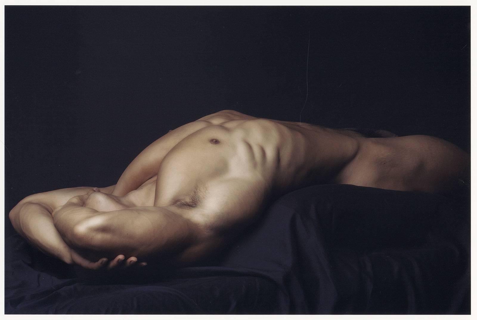 Dylan Ricci Figurative Photograph - Male Nude #135 (young male nude lying with raised arms folded across his face)