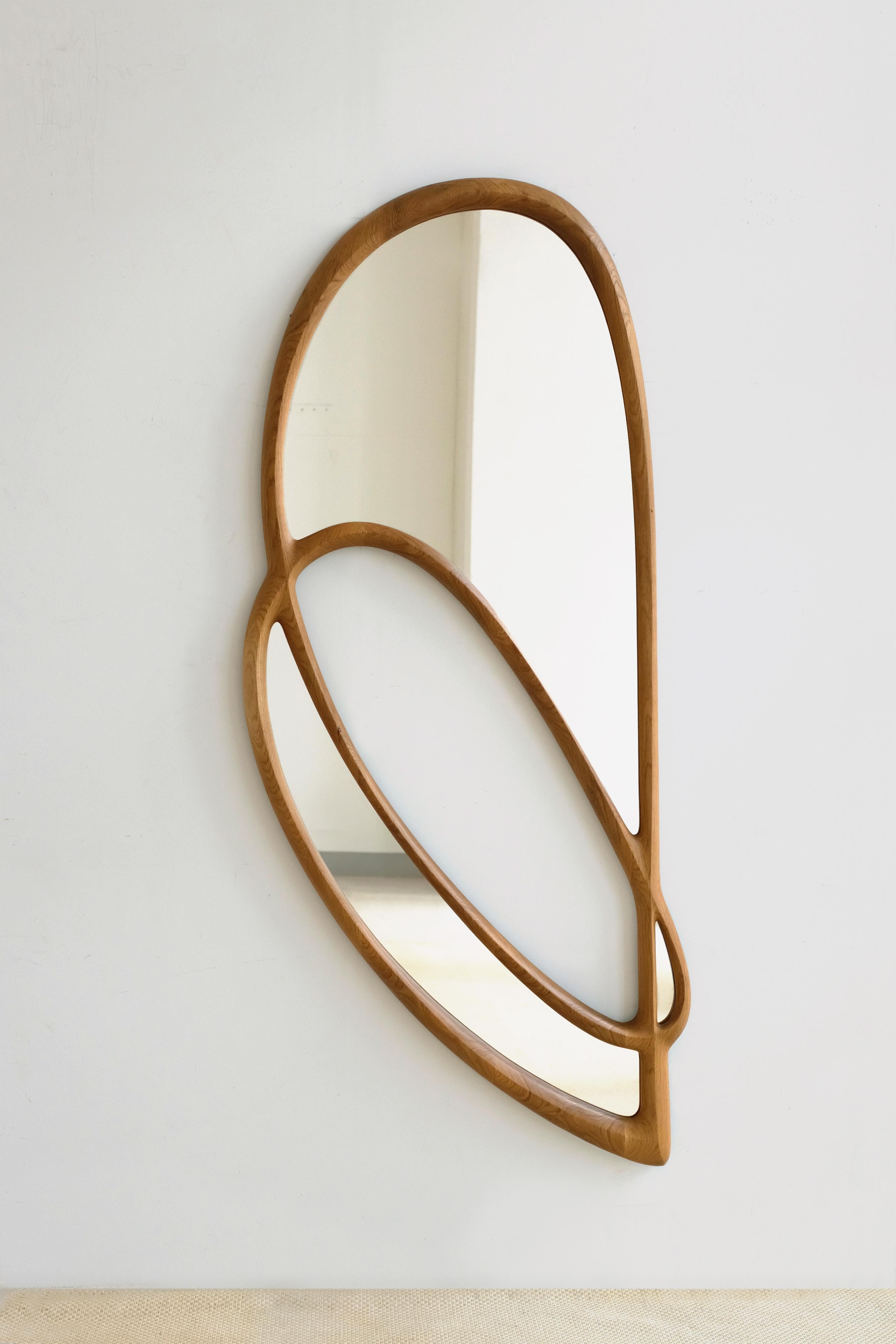 'Momentum Mirror II' by Soo Joo is a wooden wall mirror with a unique but timeless asymmetric form. It is hung with a custom-made steel French cleats, and can be hung horizontally and vertically.

This mirror silhouette is minimal but dynamic