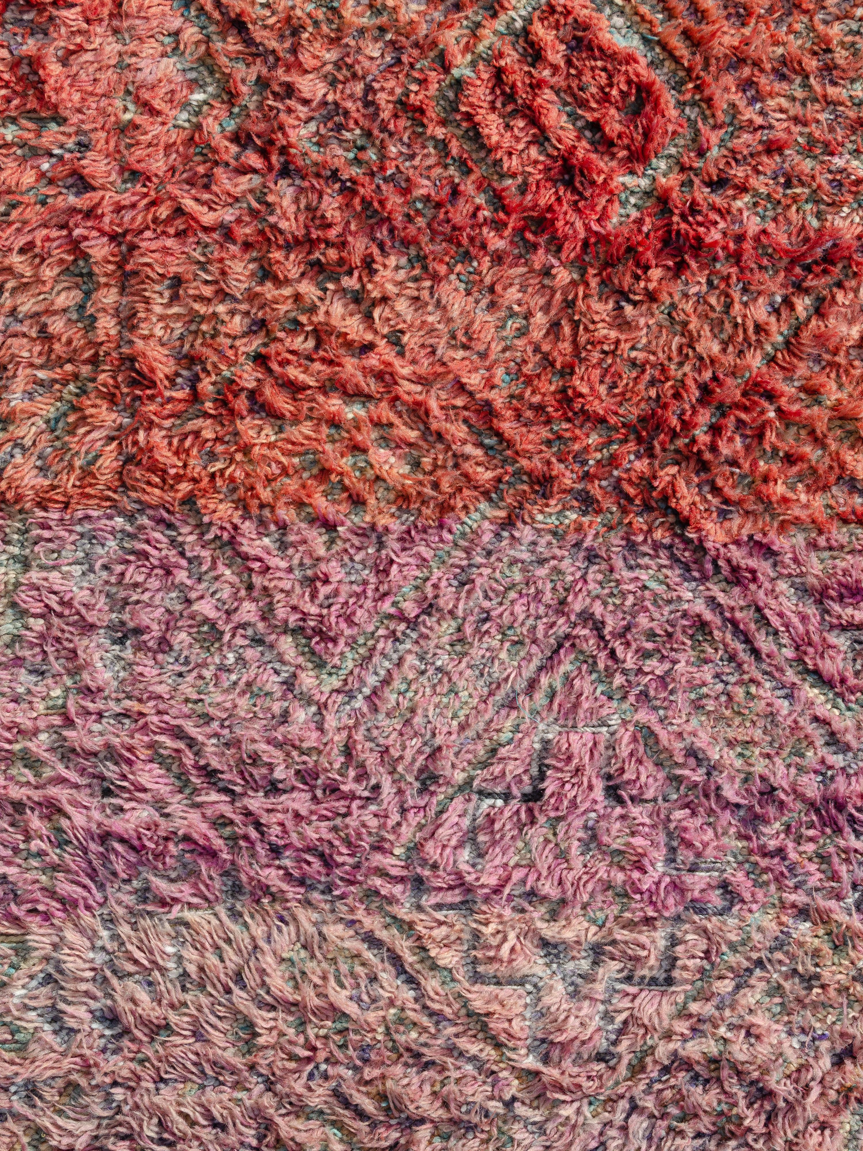 Classic with a twist, this vintage Beni M’Guild features a field of lozenges appearing to shift in and out of focus as the motifs contrast against an abrashed field. A striking color story of magenta, orange, violet, salmon, and ivory lends high and