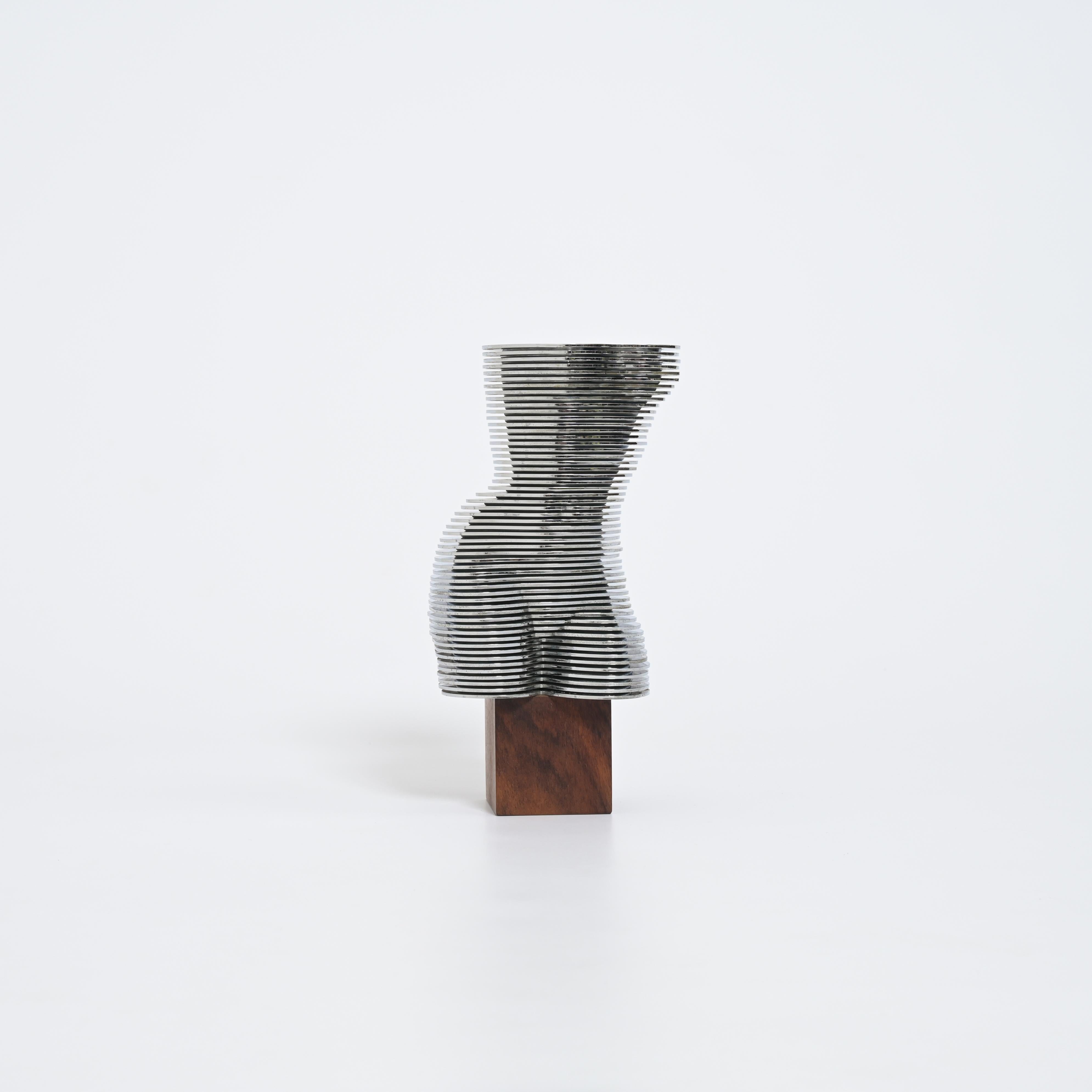 Questa scultura dinamica del busto di donna EVA è composta da 55 dischi di plastica cromata di dimensioni diverse che ruotano su un asse centrale in metallo. Ogni disco può essere spostato individualmente per formare una scultura completamente