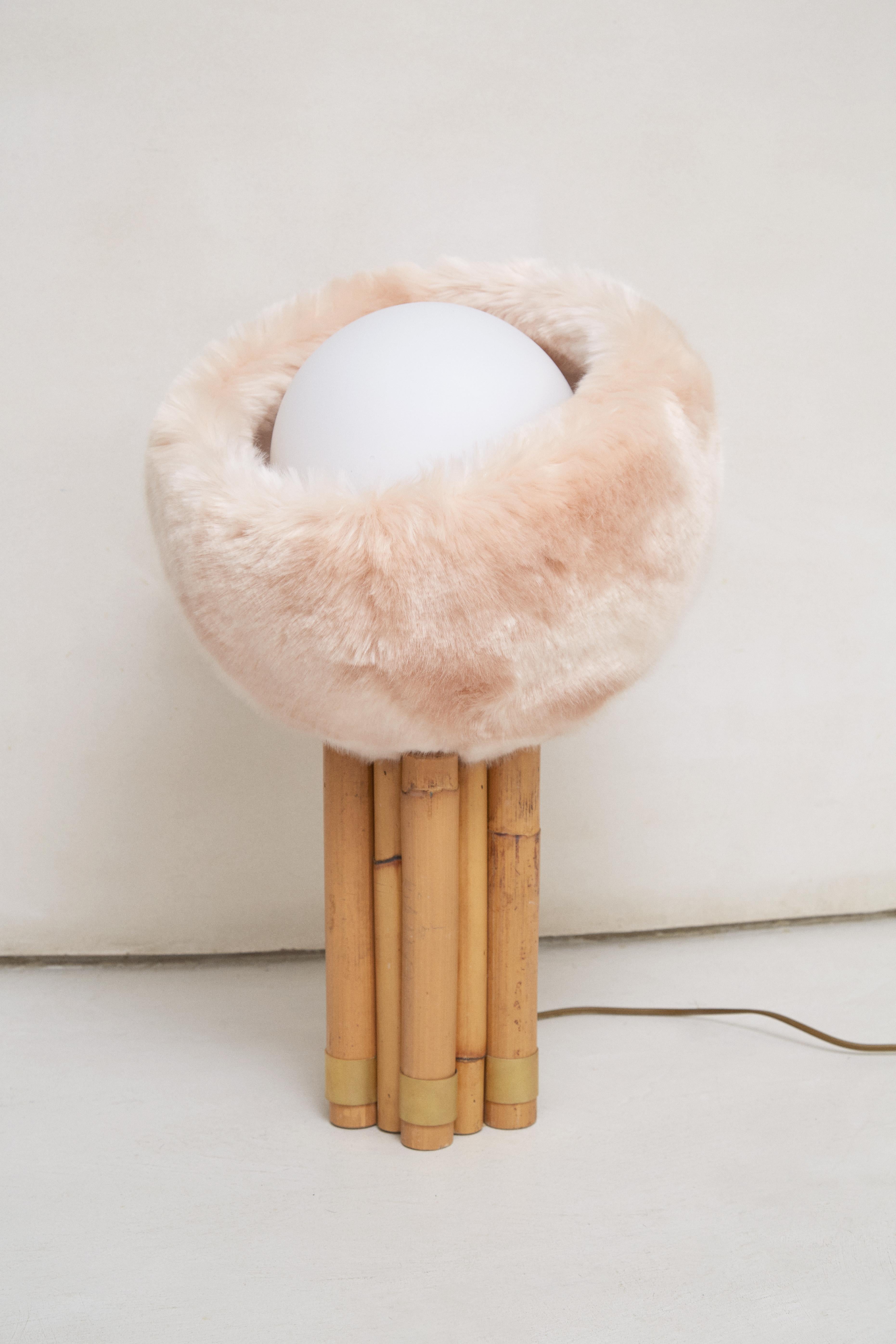 Dynamite Table Lamp by Patricia Bustos de la Torre
Dimensions: D 32 x W 35 x H 52 cm.
Materials: White opal glass, rattan and plush.

The dynamite lamp is the most emphatic of all. Hair, opal ball and a rattan
circle that are held together by a