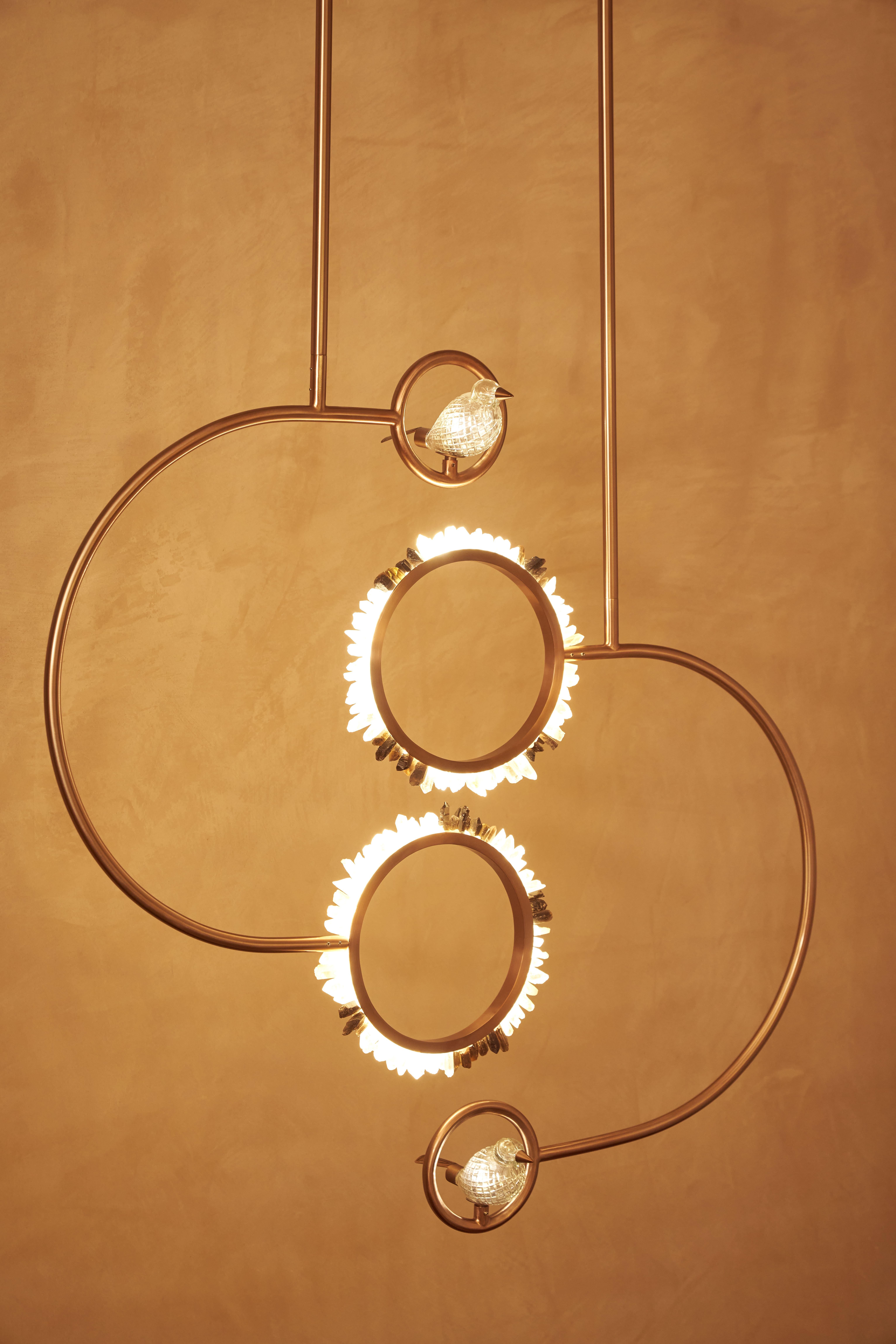 Ajoutez une touche d'élégance raffinée à votre espace avec cette suspension enchanteresse, véritable mélange de forme artistique et d'éclairage fonctionnel. Suspendue gracieusement, elle présente deux anneaux rayonnants ornés de cristaux