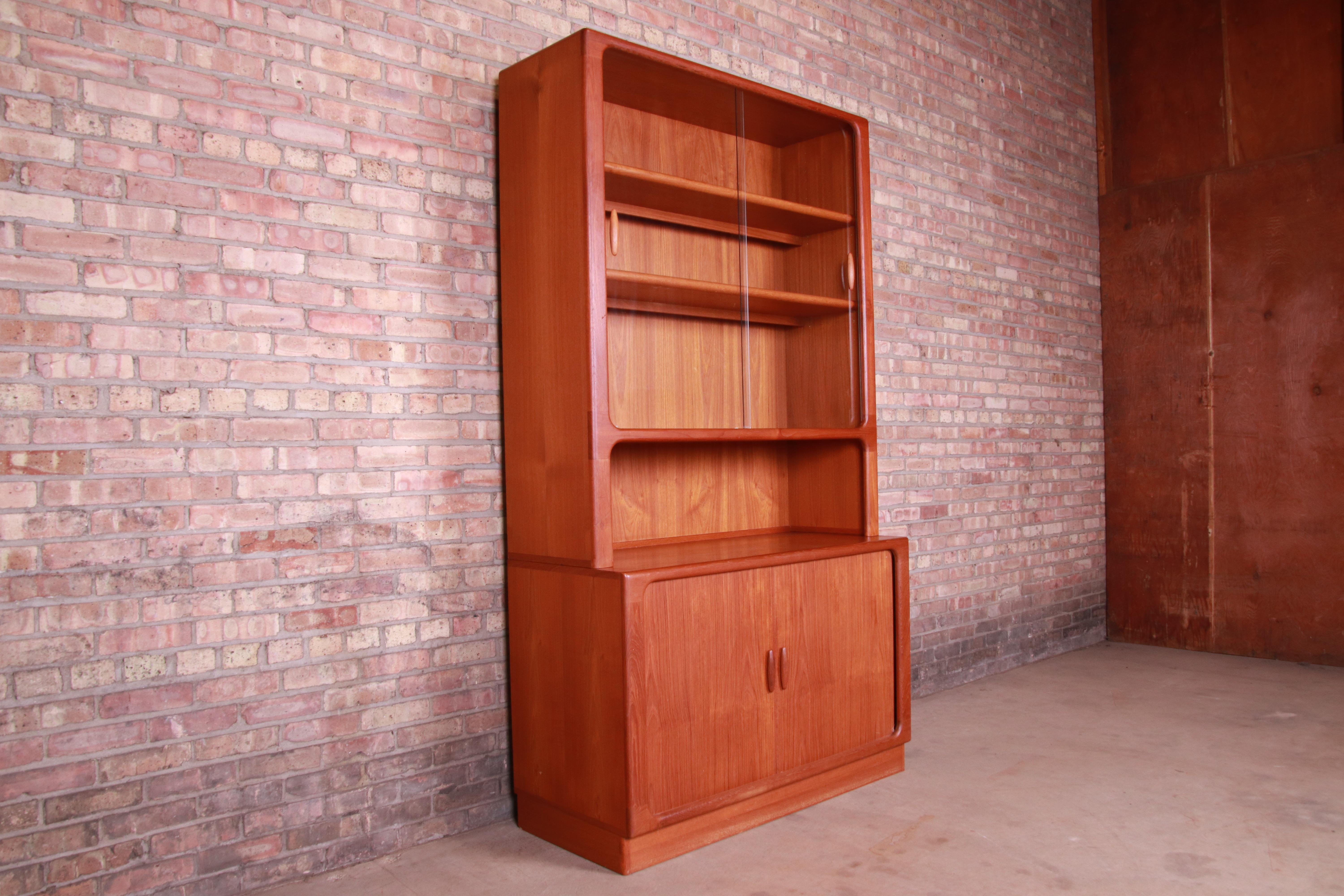 An exceptional midcentury Danish modern bookcase or bar cabinet

By Dyrlund

Denmark, circa 1960s

Teak, glass sliding doors, and interior light with European plug.

Measures: 47.25