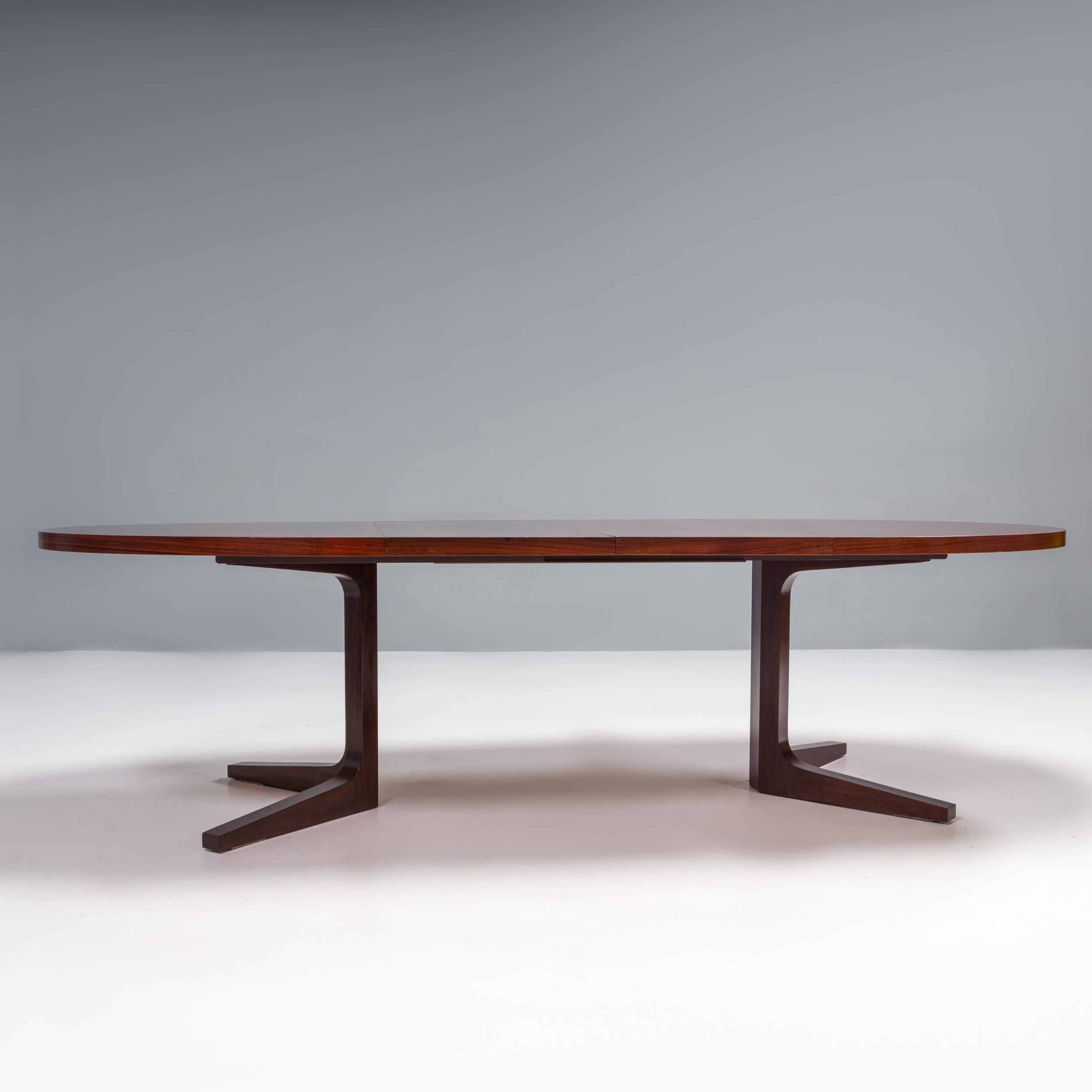 Designed and made by Dyrland in Denmark, this dining table is a classic example of mid-century modern design.

Constructed from rosewood, the dining table has a circular table top sitting on two sets of v-shaped legs, which create a four star base