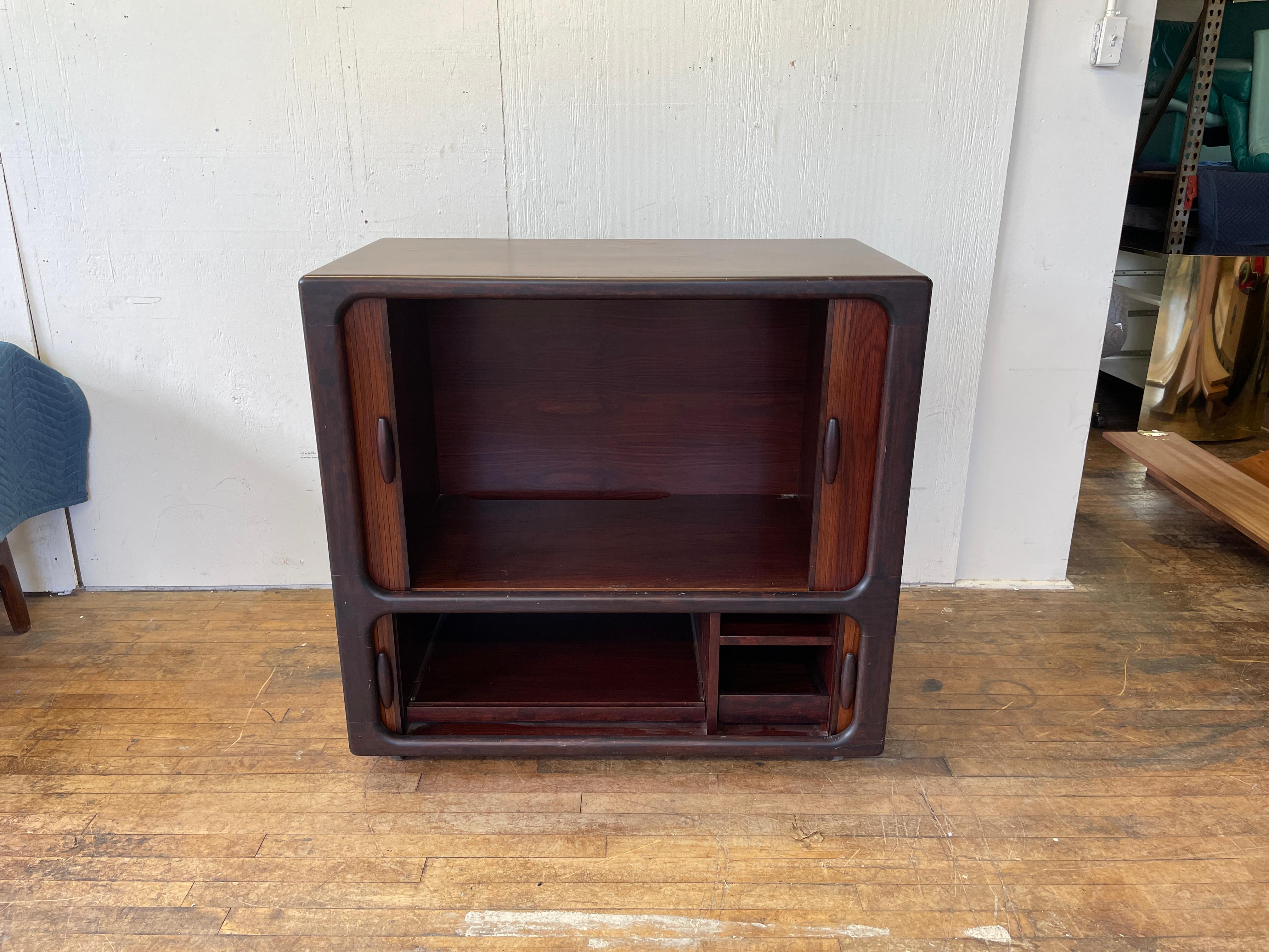 A stunning midcentury Danish modern media cabinet attributed to Dyrlund. The cabinet features two tambour door compartments for all your storage needs. Factory-made cutouts in the back allow for convenient cable management. This piece would function