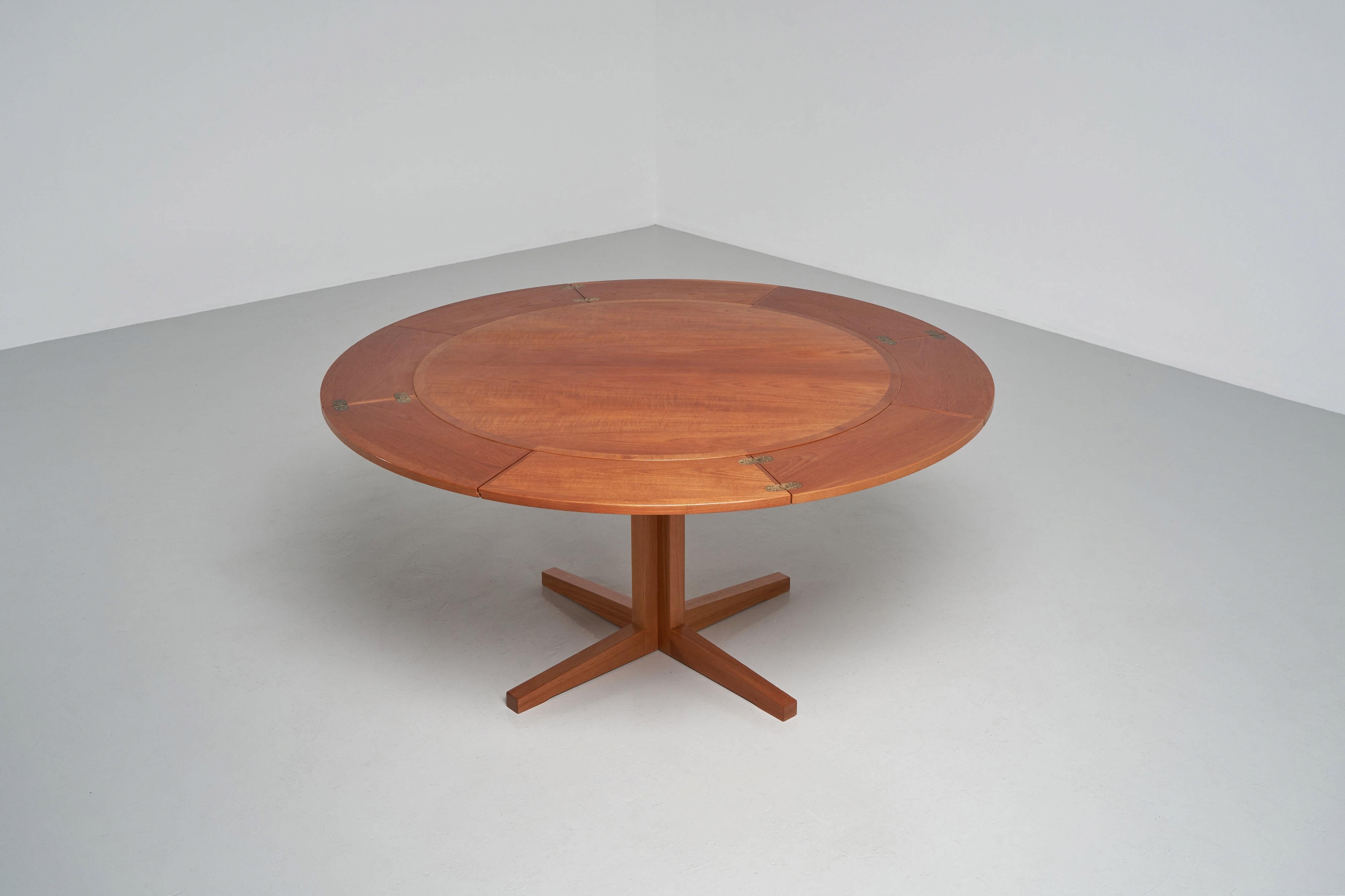 Stunning large sized round flip flap lotus top dining table designed and manufactured by Dyrlund, Denmark 1960. This table can be extended from a 110 cm diameter top to a 180 cm diameter top by unfolding the extension leaves. The four ‘flip-flap’