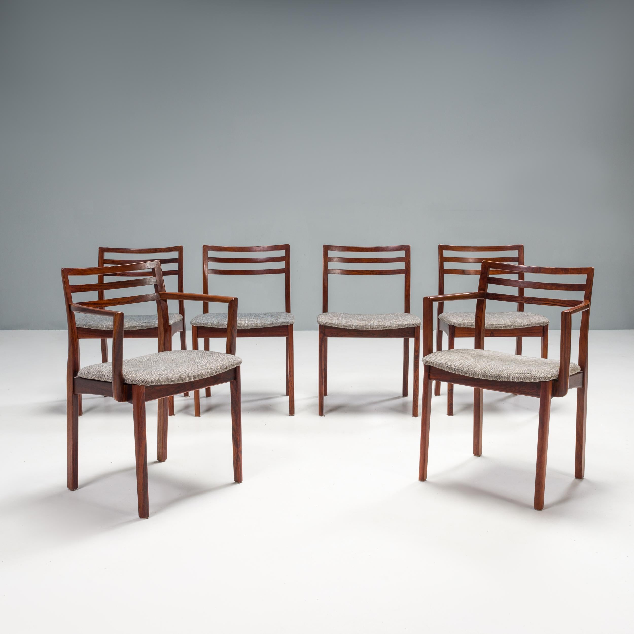 Designed and made by Dyrlund in Denmark, this set of 1960s dining chairs is a classic example of mid-century modern design.

Comprising four classic dining chairs and two carver-style chairs, the set is constructed from slim profile wooden