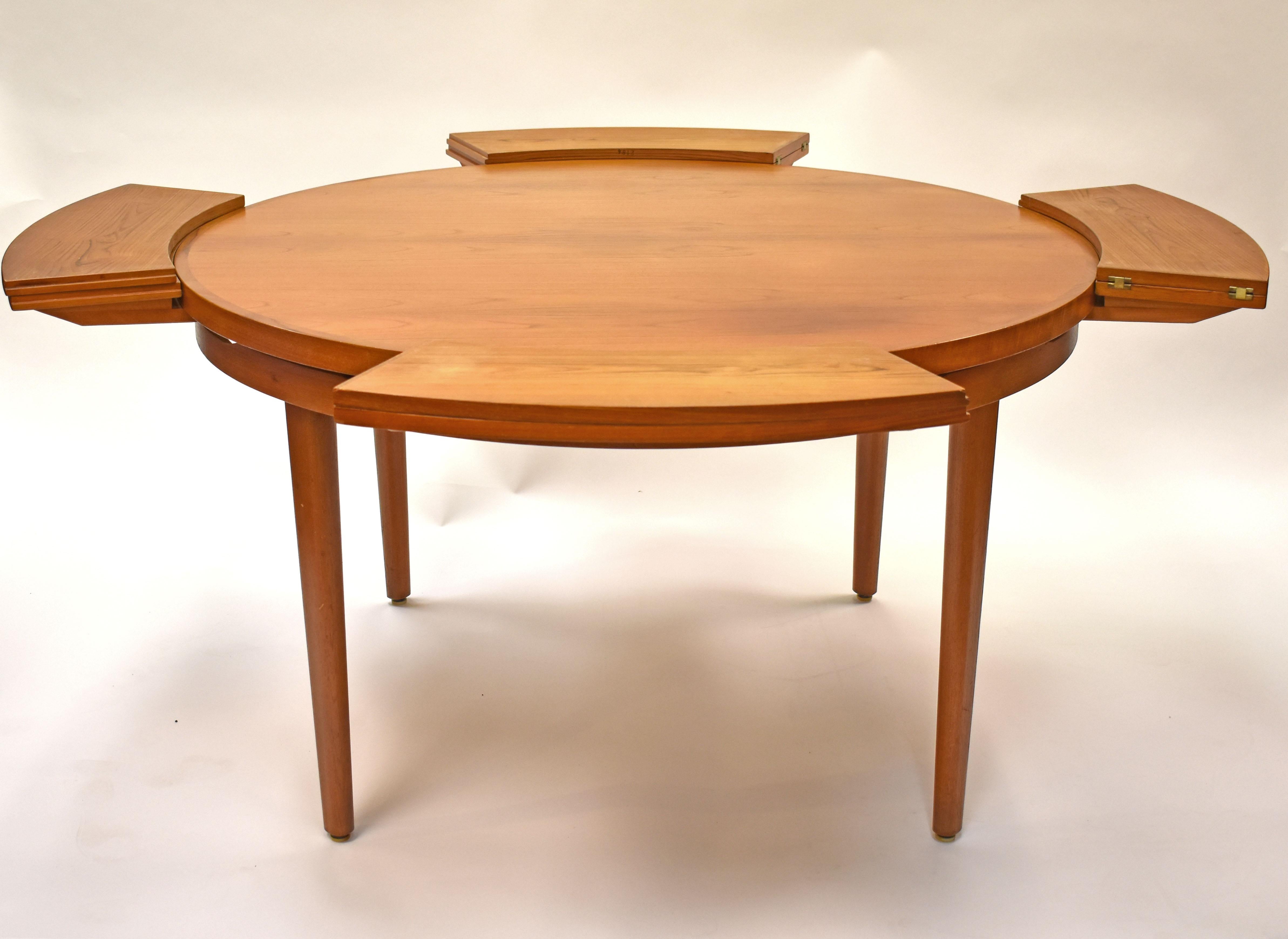 Unique and hard-to-find. This teak lotus dining table is by Dyrlund. The unusual design expands from 51
