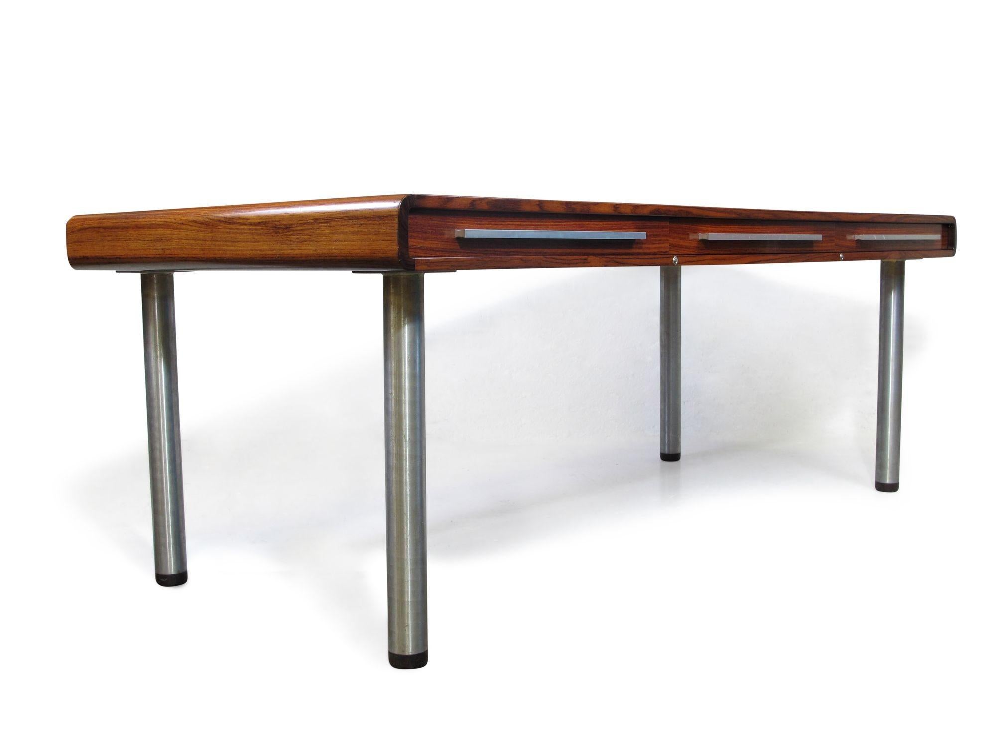 Chefschreibtisch Santos aus Palisanderholz, 1970, Dyrlund, Dänemark. Große Arbeitsfläche aus Palisanderholz mit drei großen Schubladen. Auf Metallfüßen stehend. Der Schreibtisch ist in einem guten Zustand mit geringen Alters- und Gebrauchsspuren.