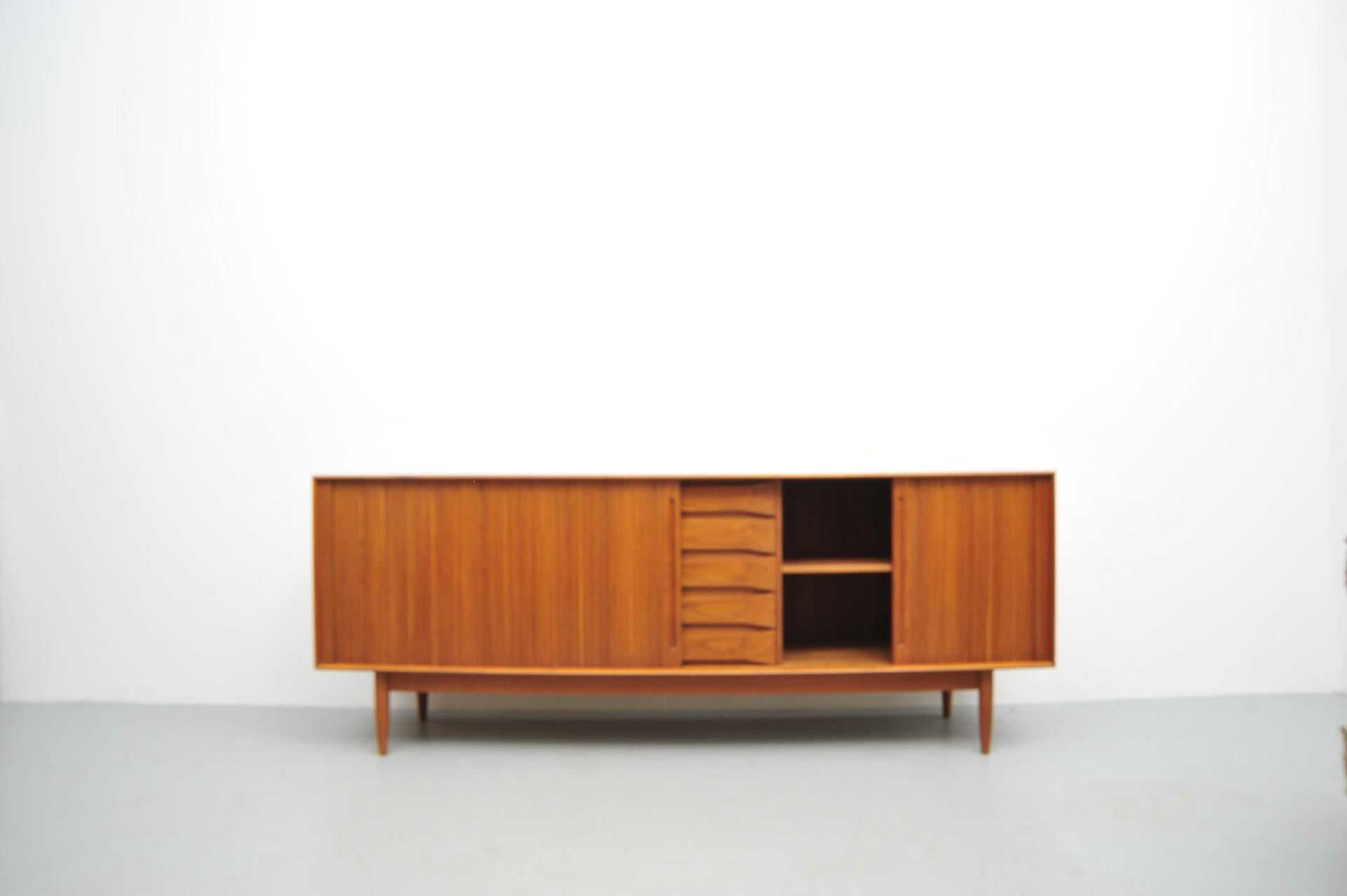 Dieses Sideboard von Dyrlund stammt aus der Design-Epoche der 1960er Jahre und repräsentiert den klassischen dänischen Designstil. Gefertigt aus massivem Teakholz, ist der Korpus durch Fingerzinken verbunden, was an die Arbeiten von Peter Hvidt
