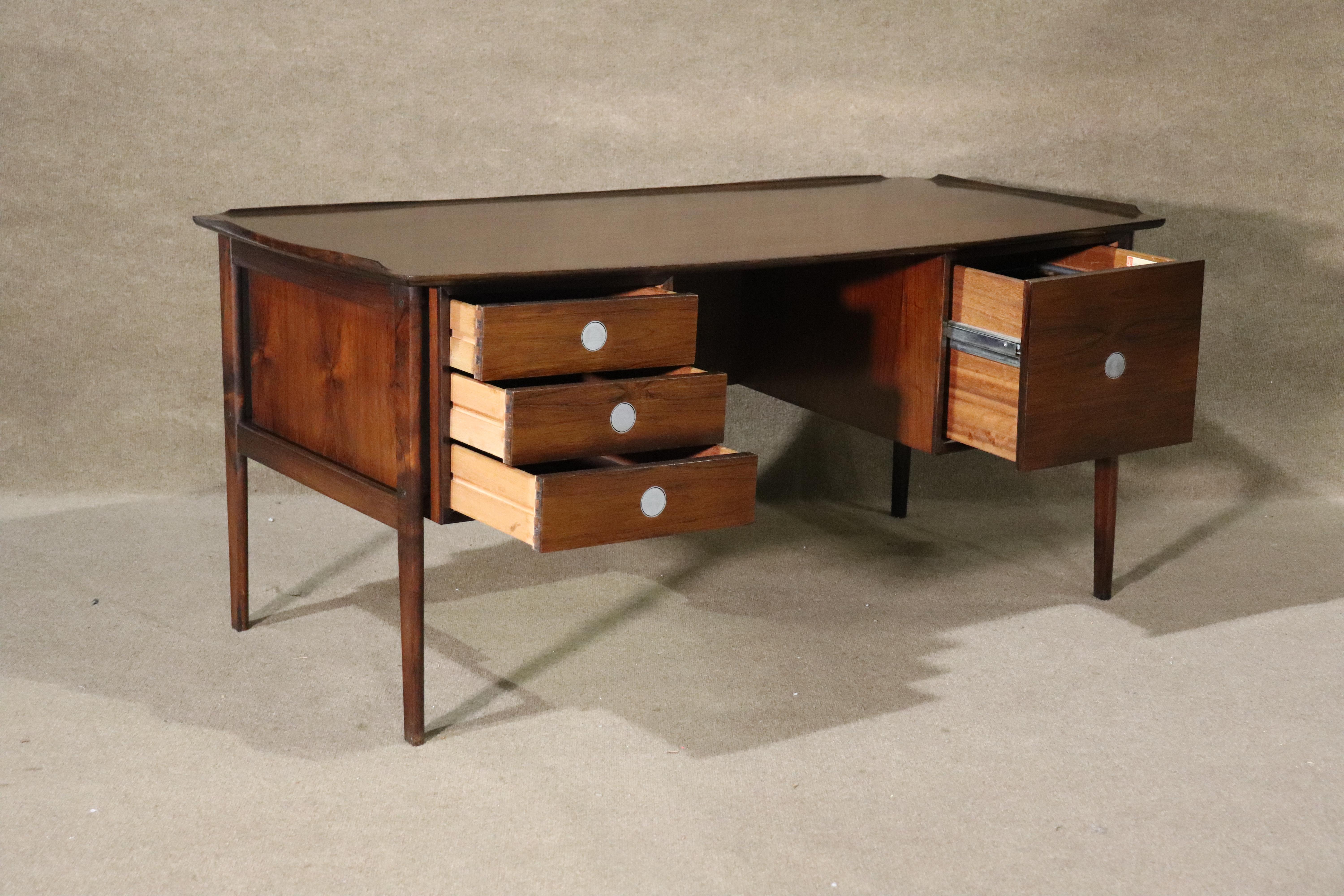 Spectacular Danish desk in rich rosewood grain. Made by Dyrlund Smith, featuring finished back, and hidden aluminum drawer pulls. Unique disc-shaped brass pulls that lay flat when closed and pivot for opening.
Please confirm location NY or NJ