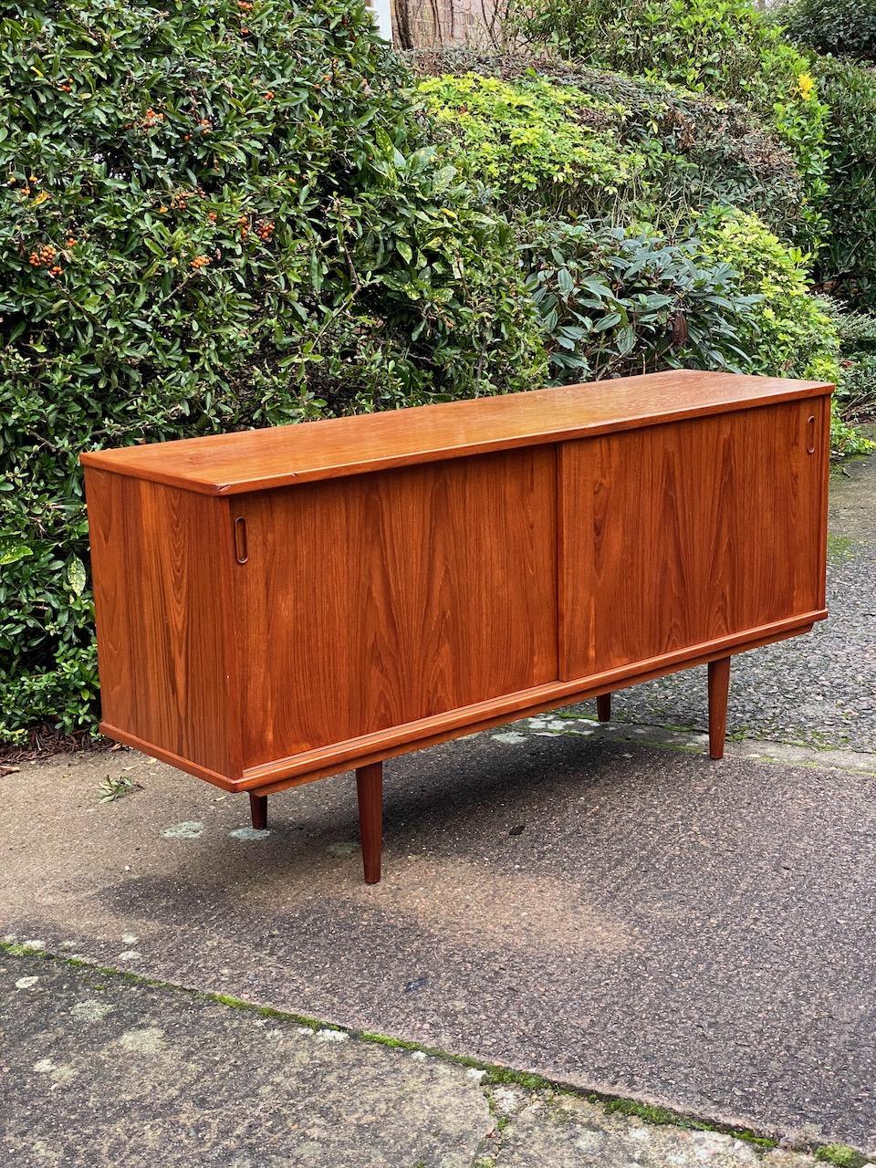 Dyrlund teak sideboard credenza midcentury Danish, circa 1970s.

Magnificent Mid-Century Modern Danish design Dyrlund teak sideboard Denmark circa 1970, the rectangular top over two cupboard with sliding doors and internal shelving, the right side