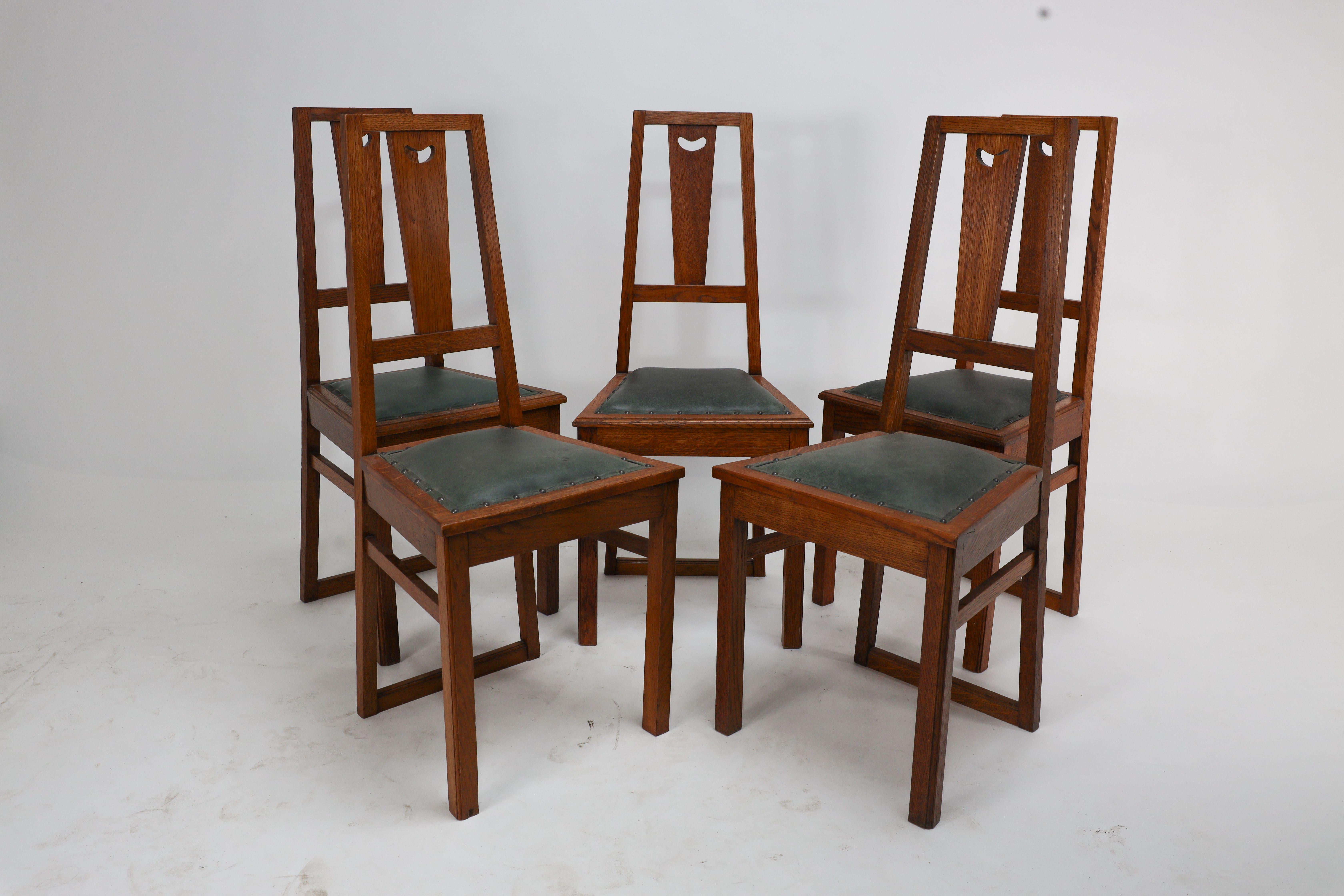 A set of five Arts and Crafts oak side chairs attributed to EA Taylor with heart cut-outs. With an 'A' frame back that continues down to unite the rear floor stretcher. Professionally re-upholstered in a quality hide.