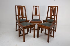 E A Taylor. A set of five Arts and Crafts oak side chairs with heart cut-outs.