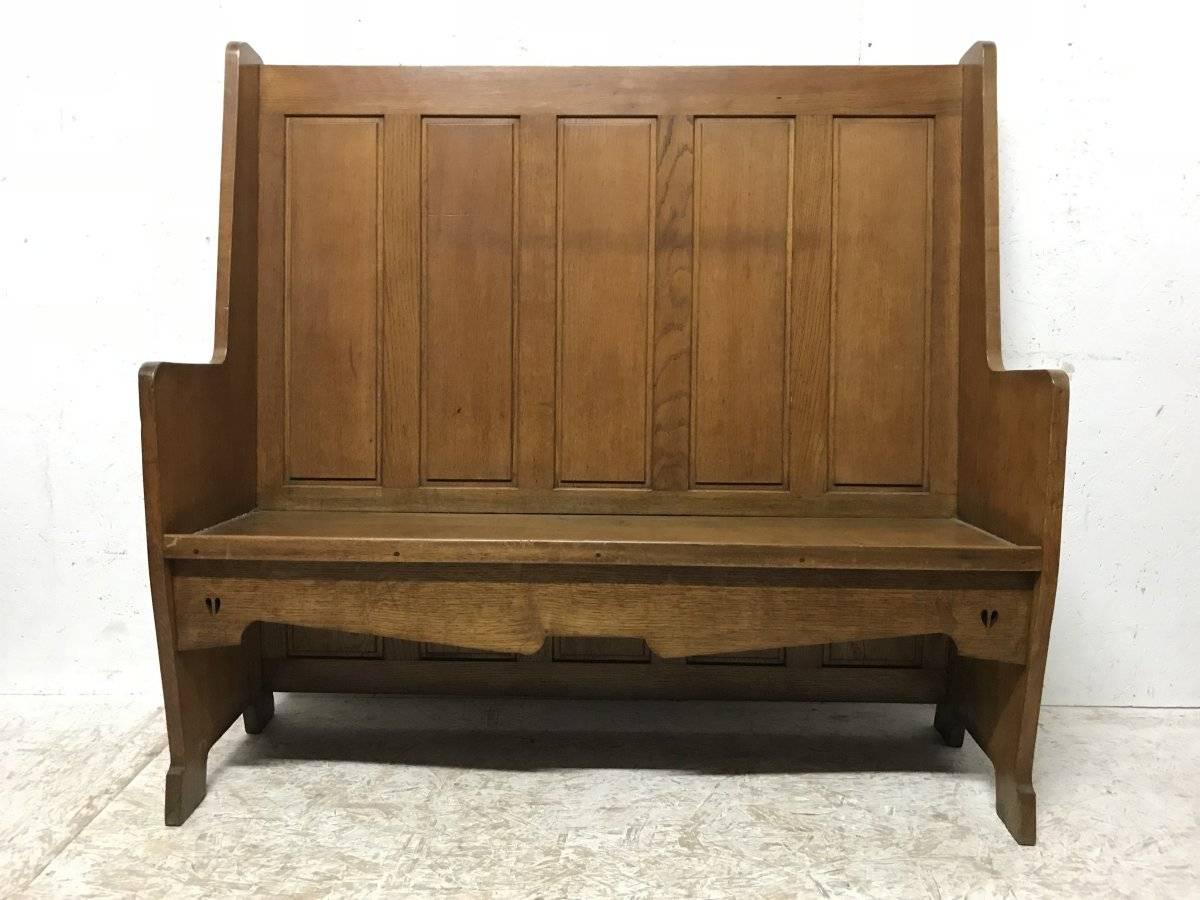 E A Taylor attr probably made by Wylie and Lochhead of Glasgow.
An Arts & Crafts oak panelled high back settle with twin heart cut-outs just below the seat with a later made cushion.